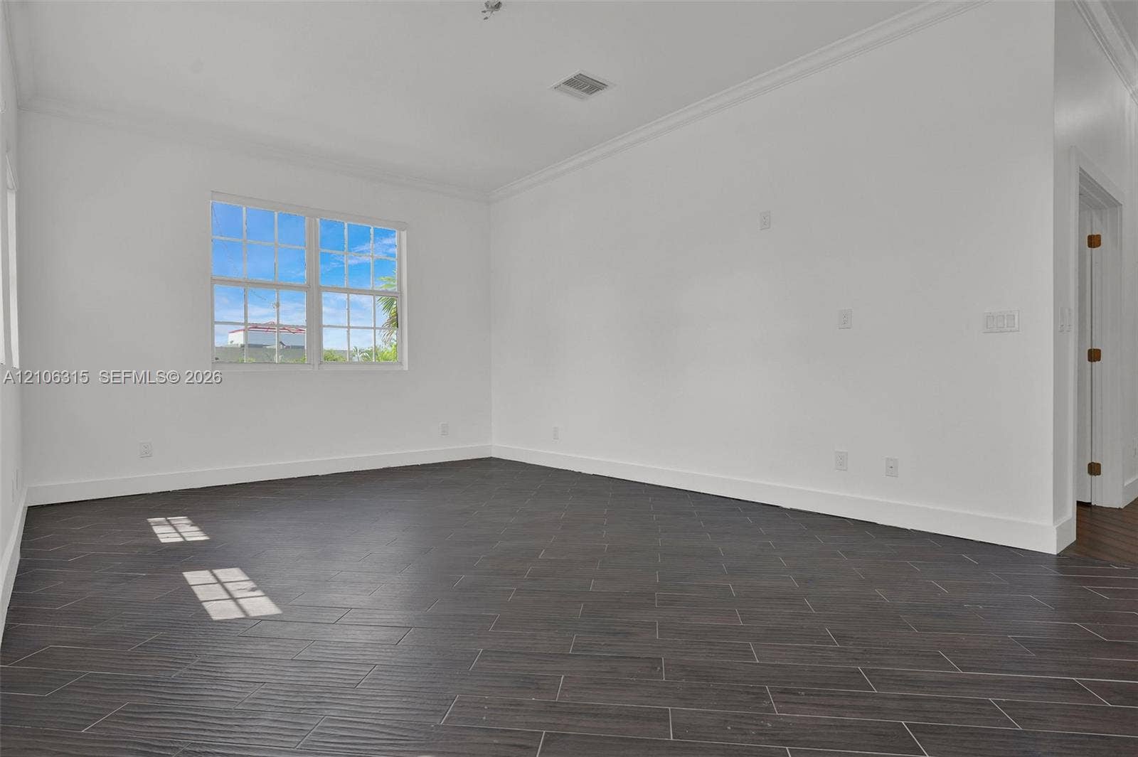 2319 NE 35th Drive, Fort Lauderdale, FL 33308 Interior room featuring wood-finish tile flooring, multi-pane window, and crown molding