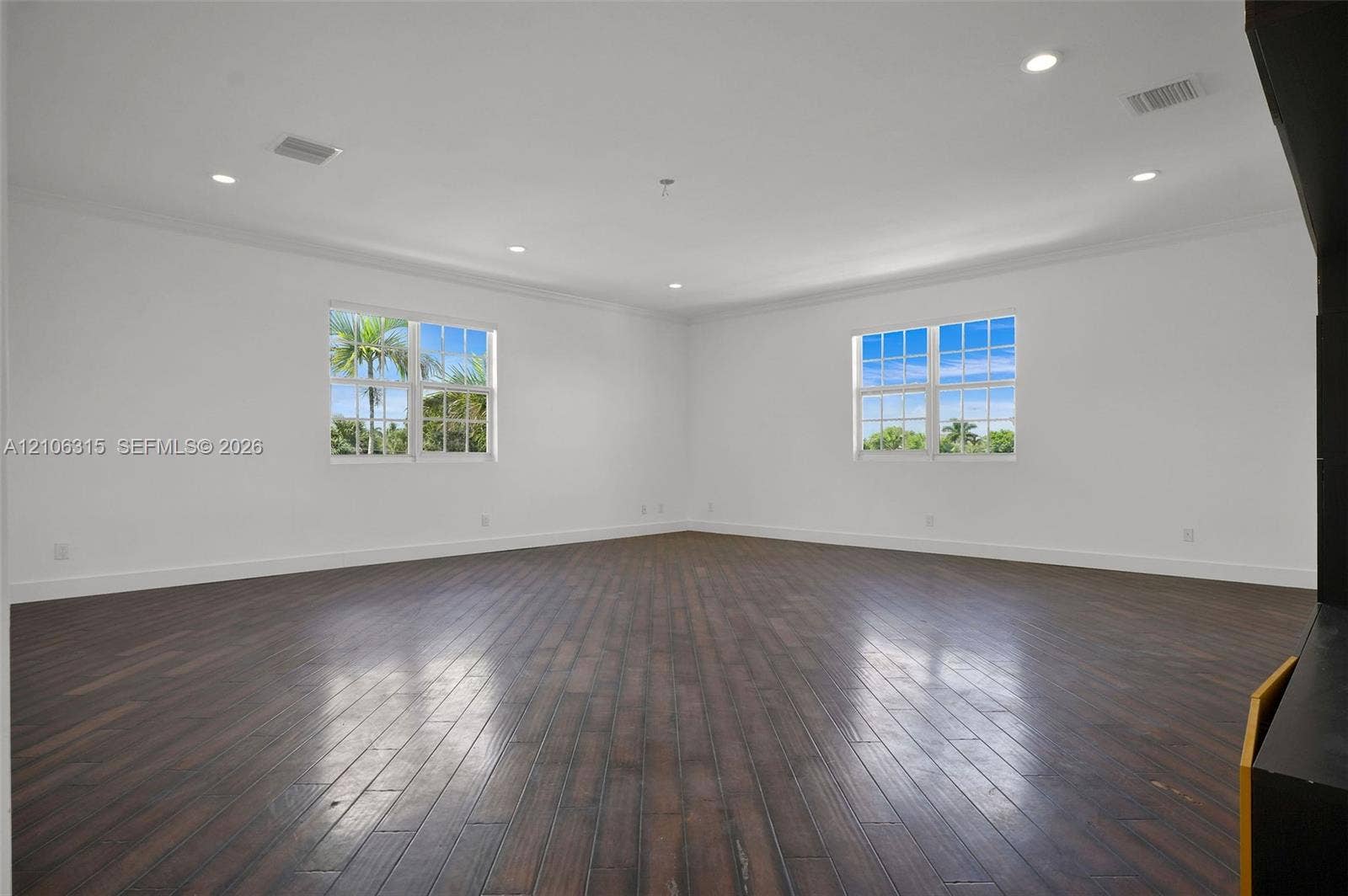 2319 NE 35th Drive, Fort Lauderdale, FL 33308 Expansive living area featuring wood-finish flooring, recessed lighting, crown molding, and large grid-patterned windows