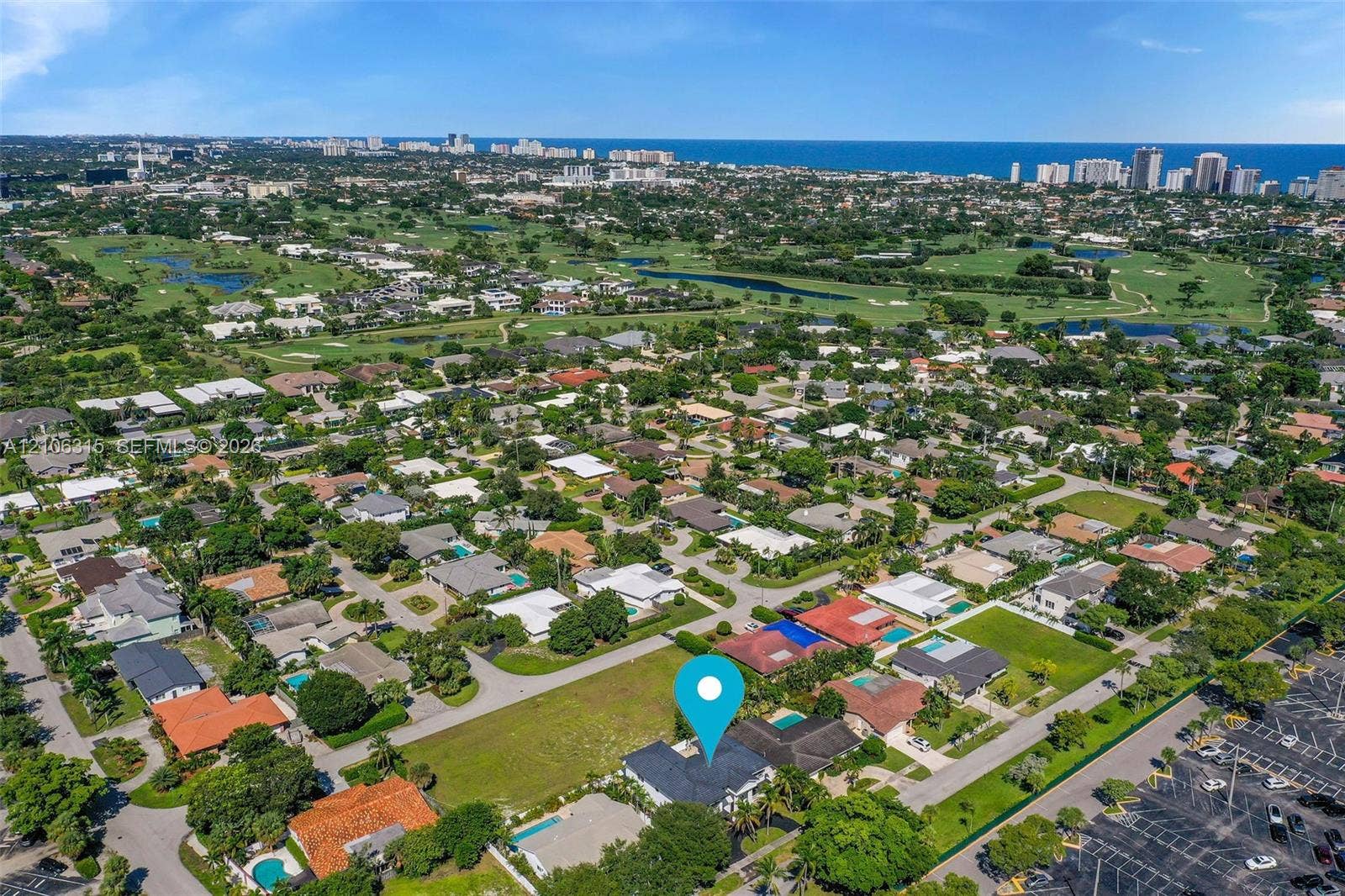 2319 NE 35th Drive, Fort Lauderdale, FL 33308 Aerial perspective showcasing a coastal suburban location with prominent proximity to golf course grounds and ocean horizon lines
