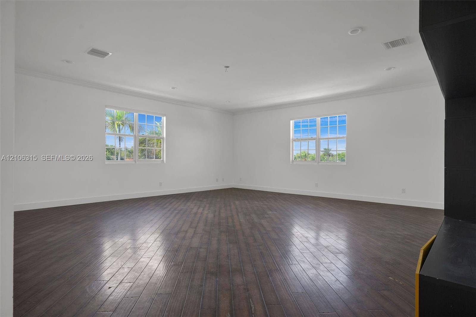2319 NE 35th Drive, Fort Lauderdale, FL 33308 Interior space featuring dark wood-finish flooring, multi-pane windows, recessed lighting, and crown molding