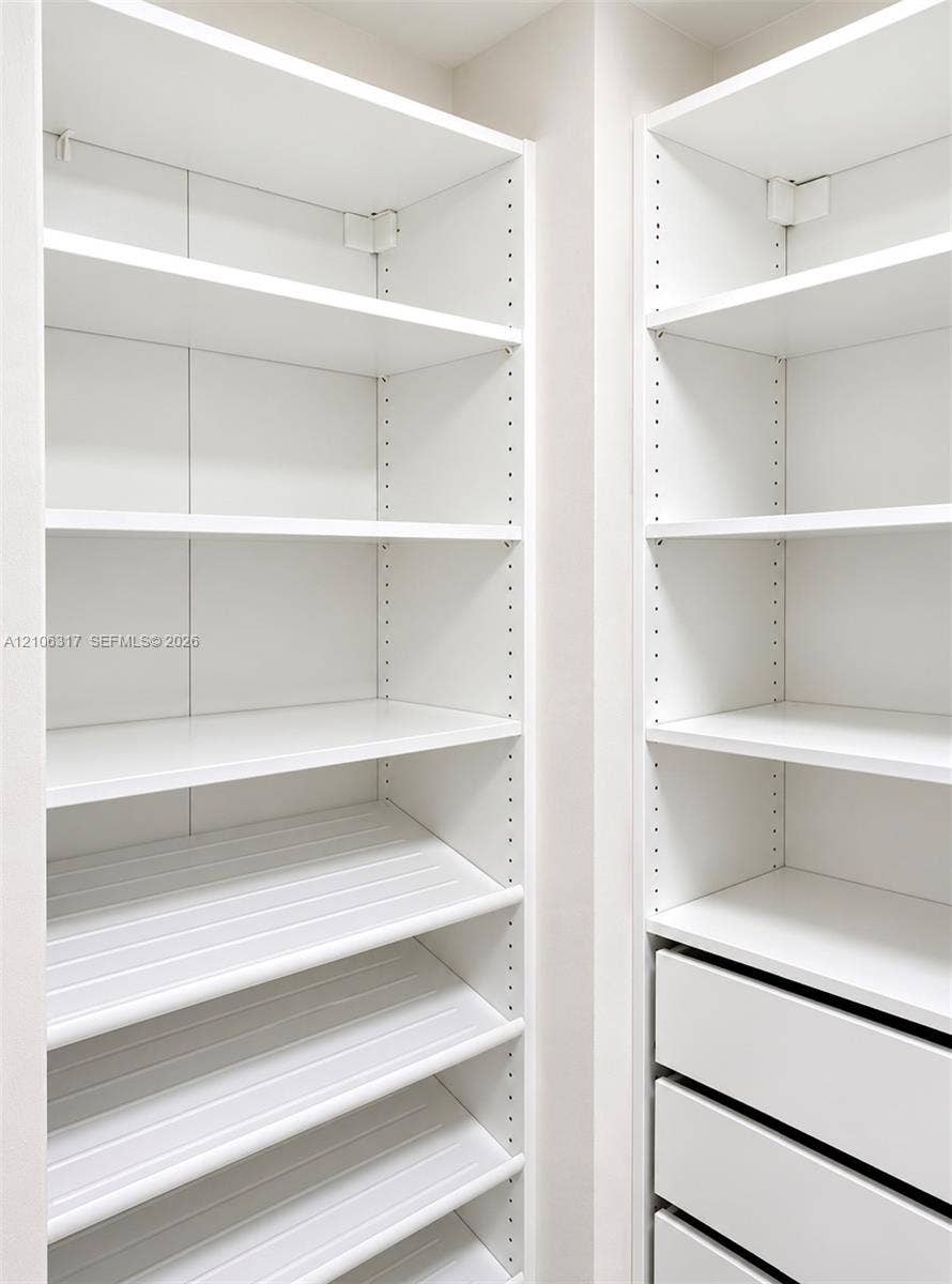 Custom white shelving system featuring adjustable heights, integrated storage drawers, and specialized angled shoe storage shelving