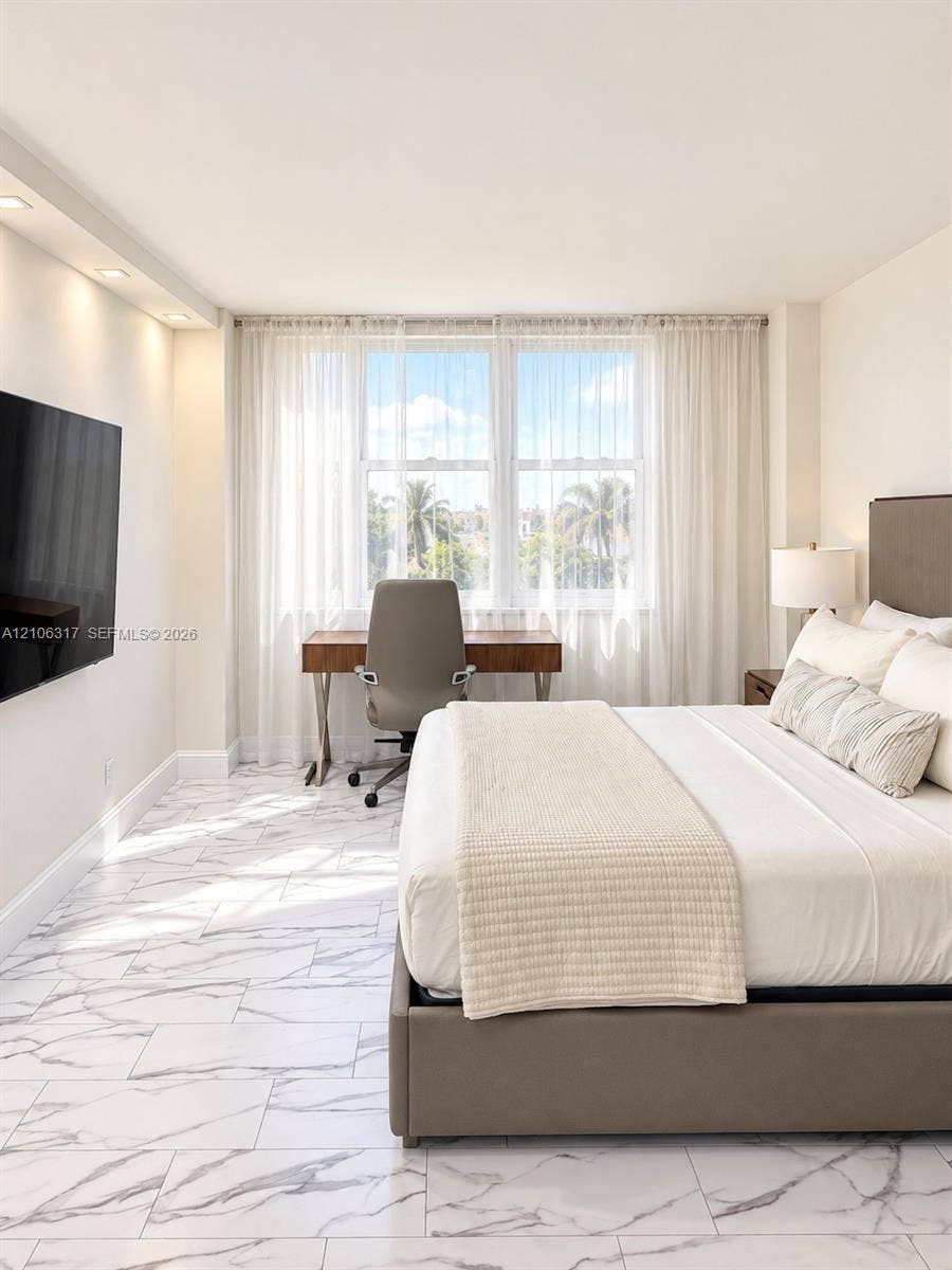 Large-format stone-style tile flooring, recessed ceiling lighting, and expansive windows