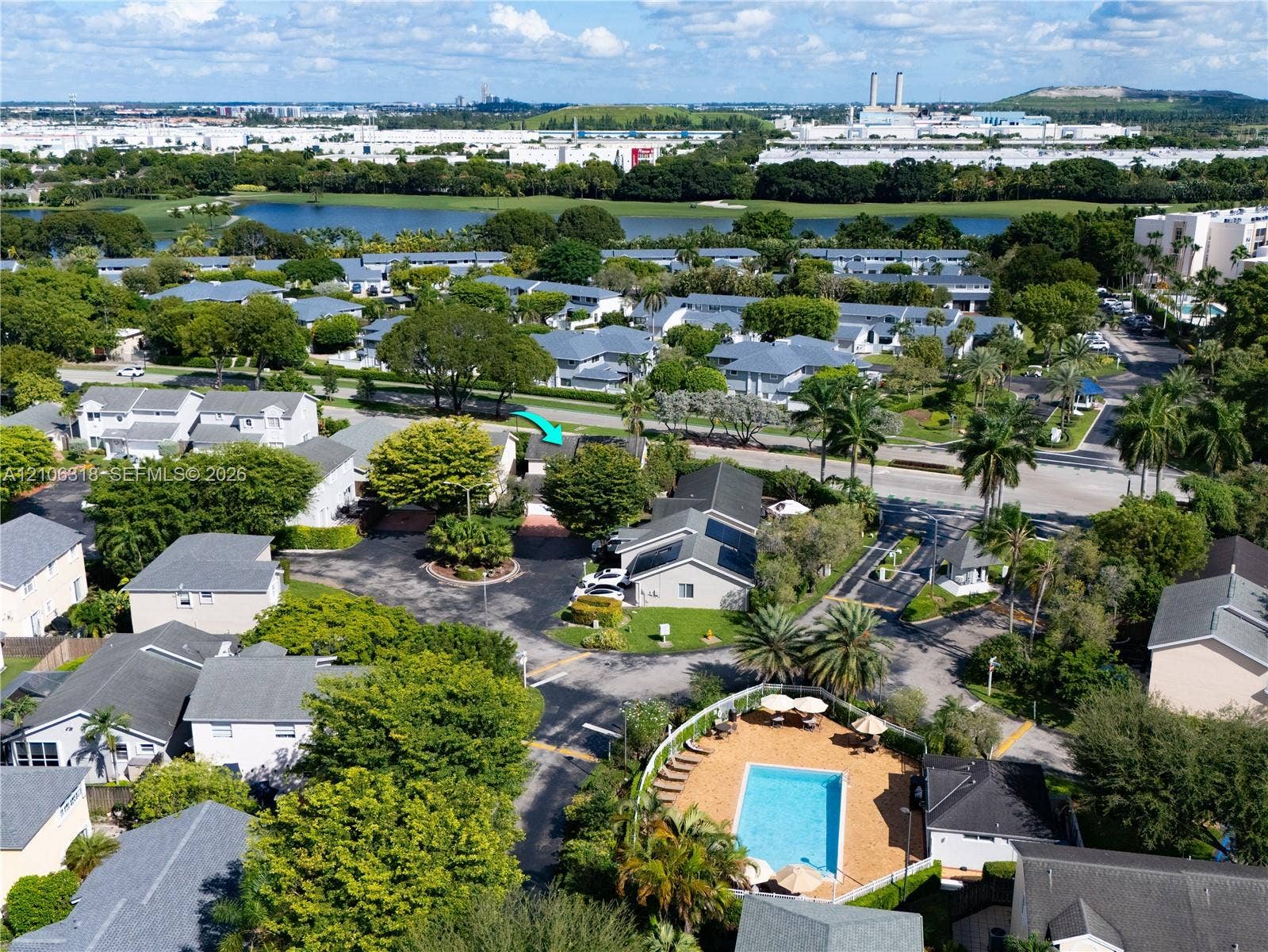 9921 NW 51st Lane, Doral, FL 33178 Aerial perspective featuring a residential community with mature landscaping, a swimming pool, and water features
