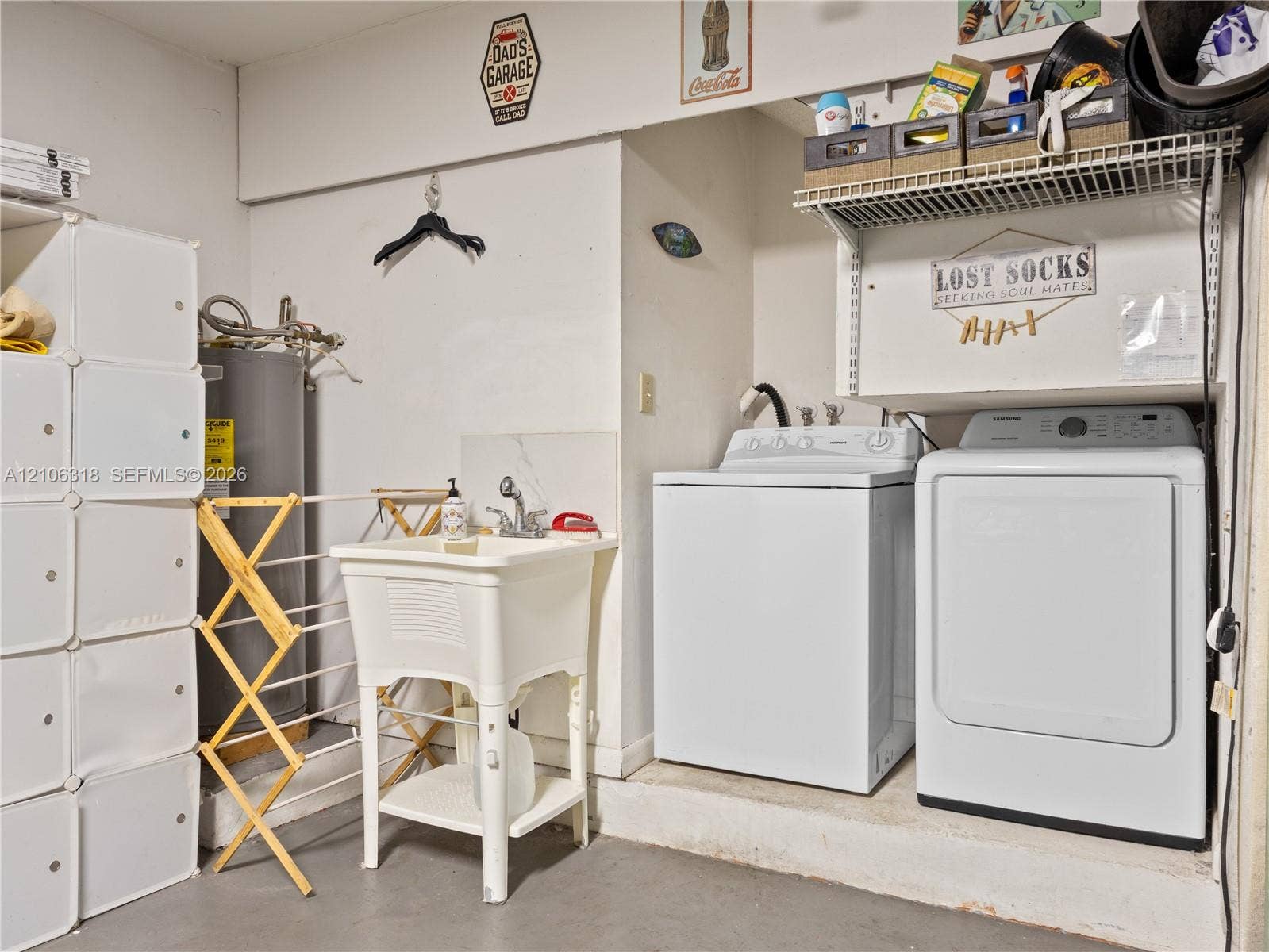 9921 NW 51st Lane, Doral, FL 33178 Utility area featuring a freestanding basin sink with a high-arch faucet, wall-mounted wire shelving, and dedicated laundry hookups