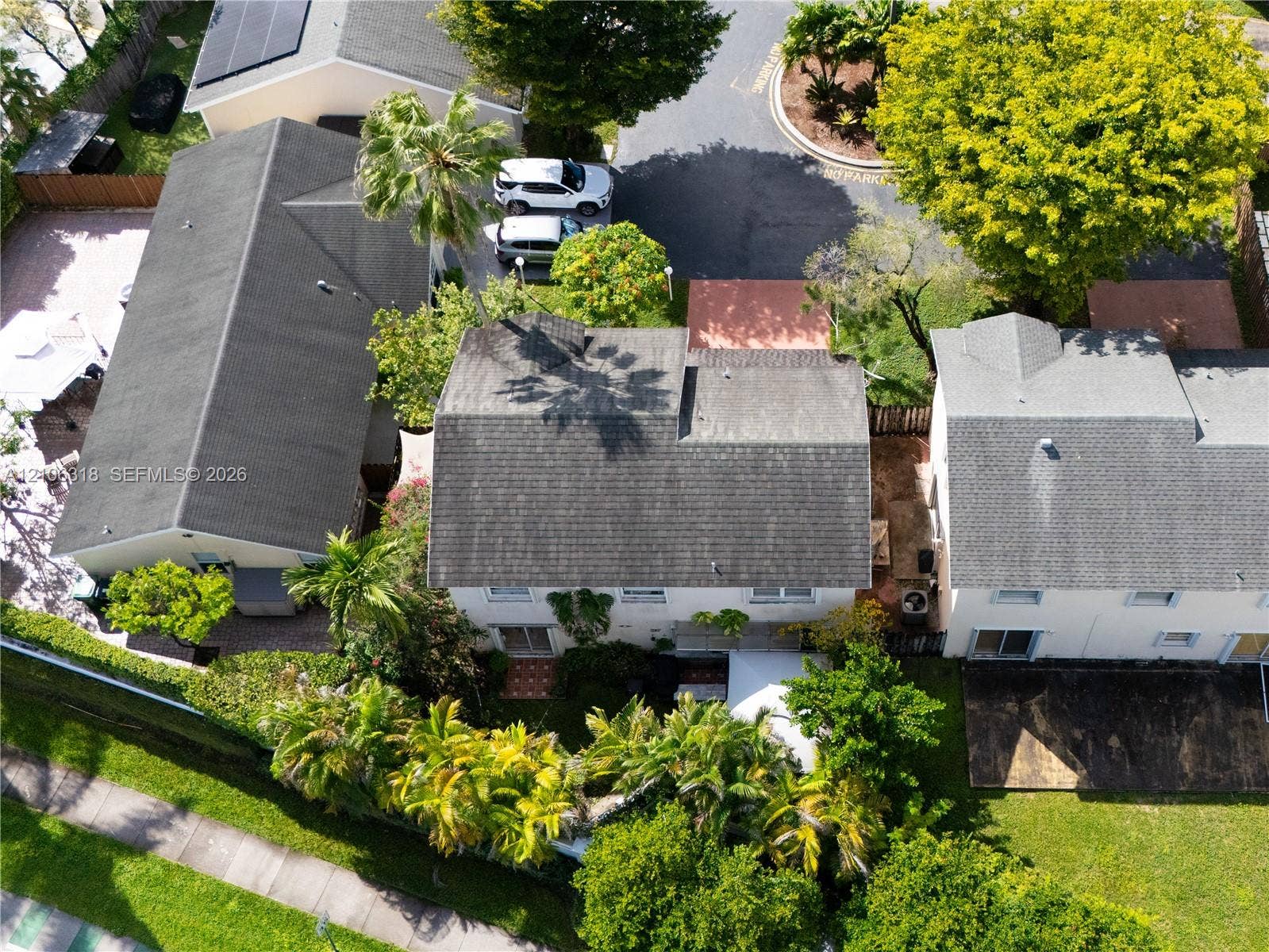 9921 NW 51st Lane, Doral, FL 33178 Aerial perspective featuring a multi-story residence with a shingled roof, attached garage, private rear patio area, and mature landscaping