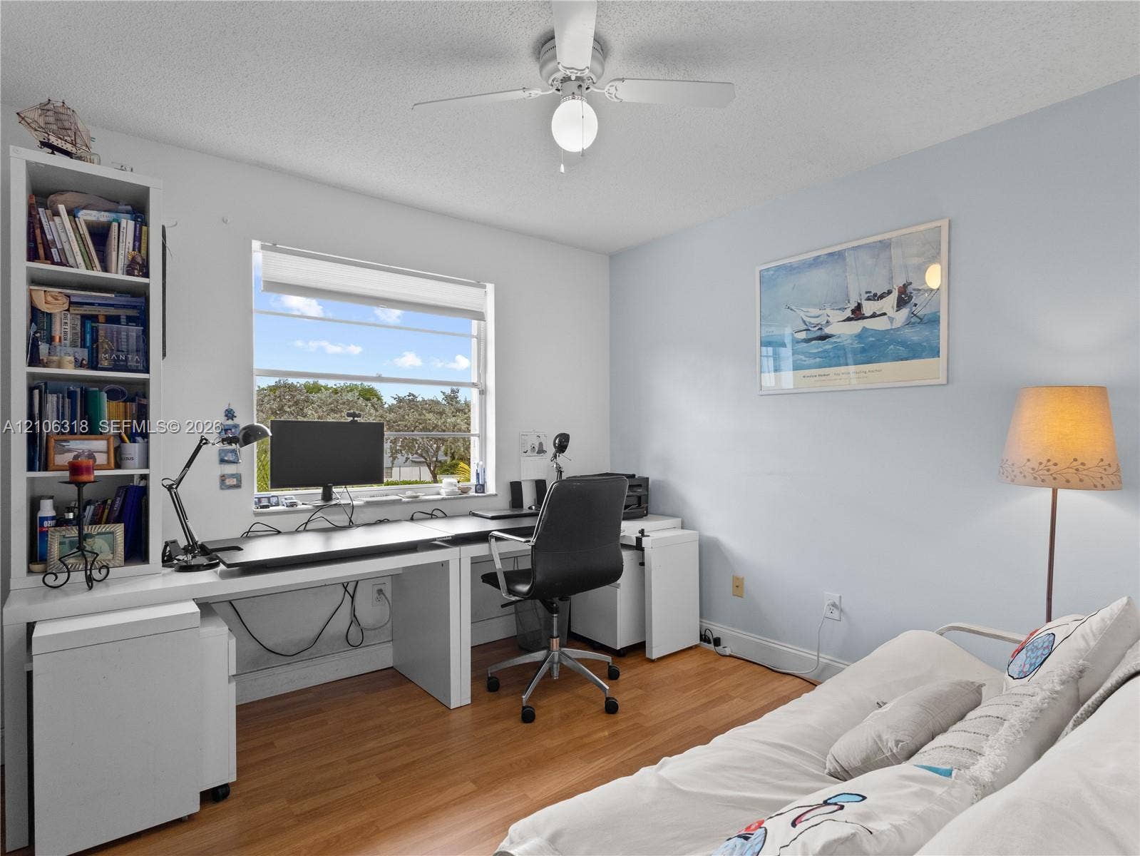 9921 NW 51st Lane, Doral, FL 33178 Wood-finish flooring, built-in shelving unit, multi-pane window, and central ceiling fan with integrated light fixture