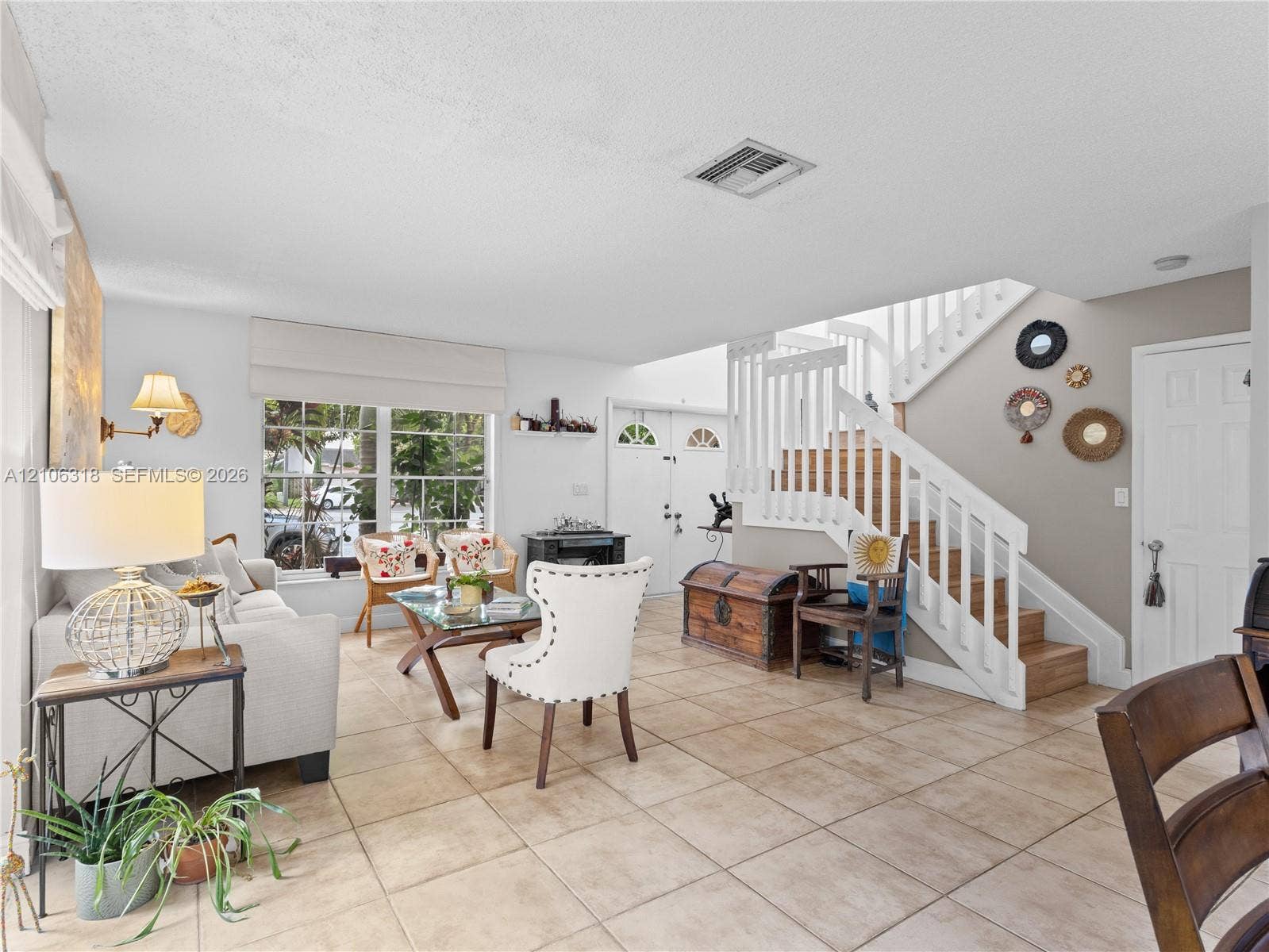 9921 NW 51st Lane, Doral, FL 33178 Open-concept living space featuring large-format tile flooring, a multi-pane window with Roman shades