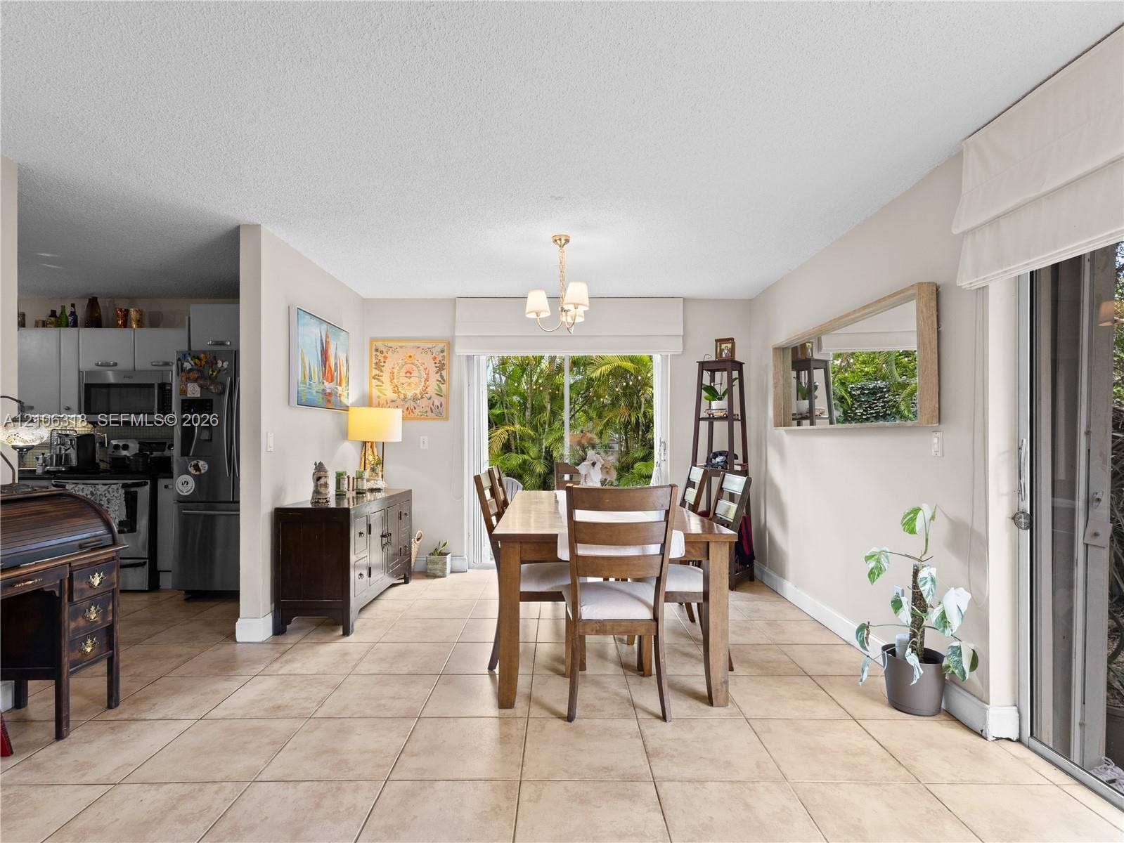 9921 NW 51st Lane, Doral, FL 33178 Ceramic tile flooring, neutral wall tones, multi-light chandelier, and large sliding glass doors
