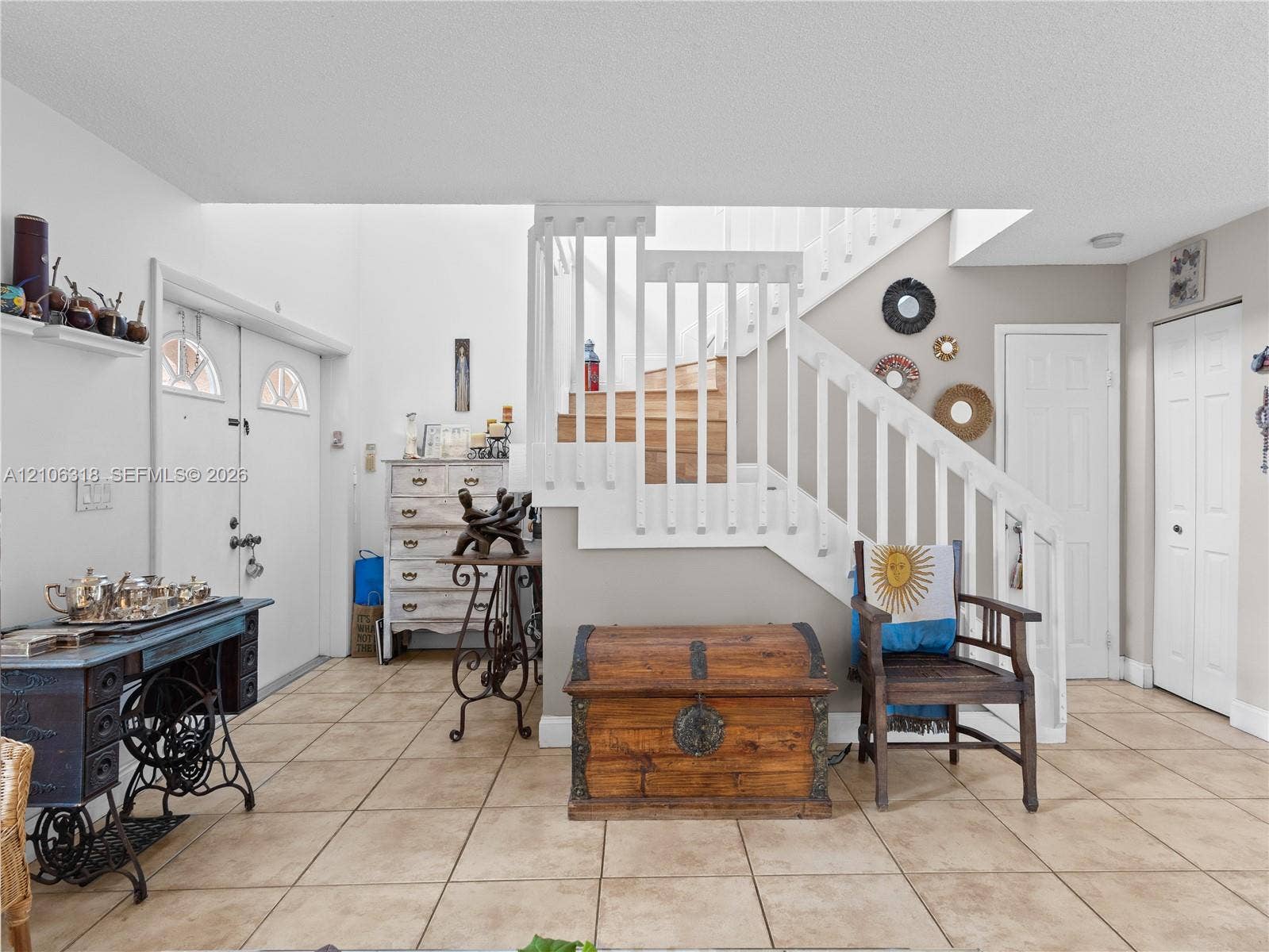 9921 NW 51st Lane, Doral, FL 33178 Entryway featuring ceramic tile flooring, a staircase with white balusters and wooden treads, double entry doors with integrated window panes, and interior doors with paneled detailing