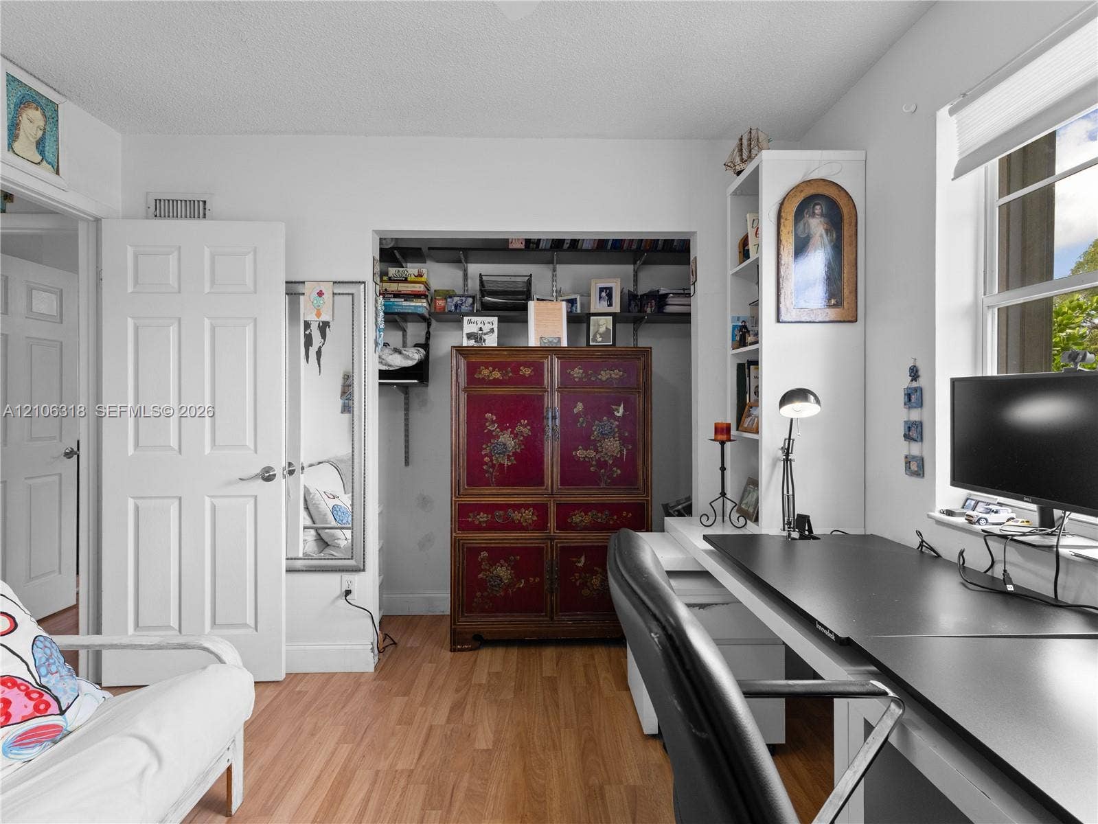 9921 NW 51st Lane, Doral, FL 33178 Wood-finish flooring, built-in shelving, expansive closet with open storage, and a multi-pane window