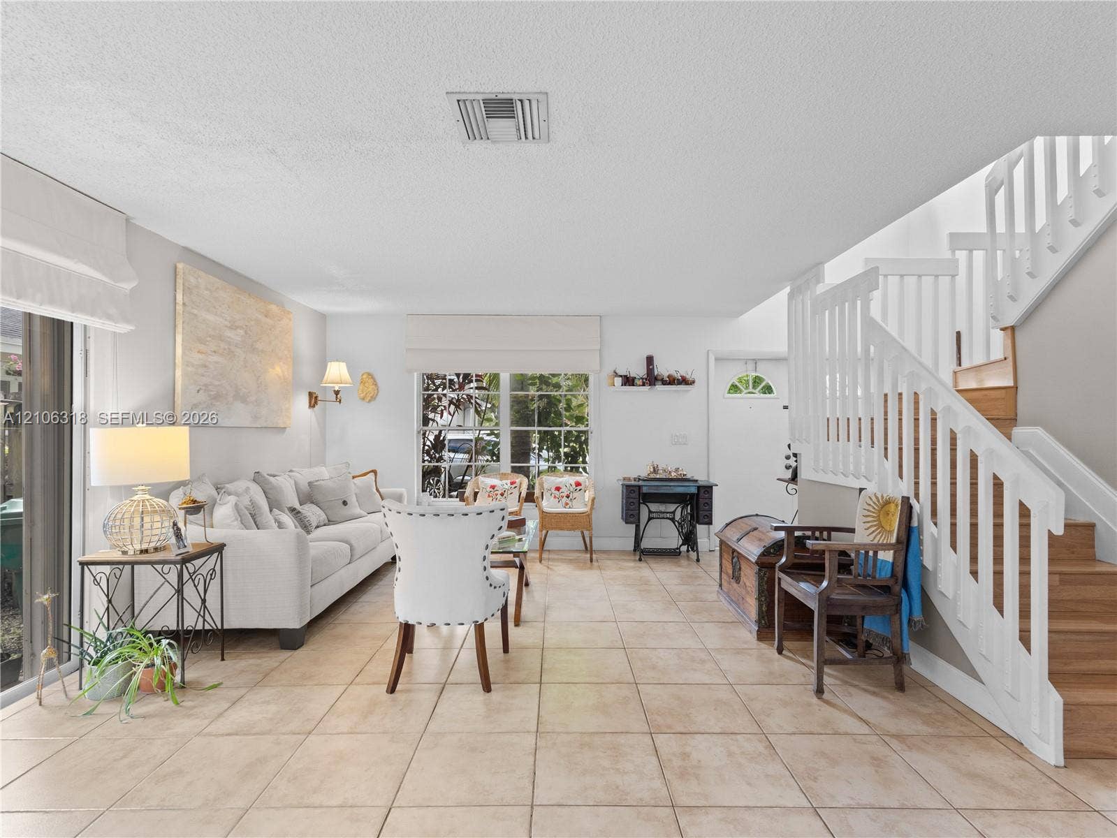 9921 NW 51st Lane, Doral, FL 33178 Open-concept space featuring tile flooring, staircase with white wooden balusters, and large glass sliding doors