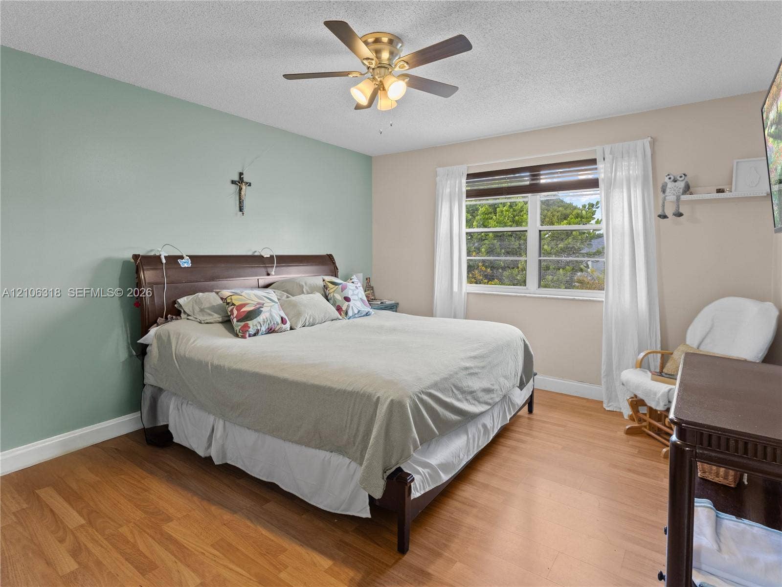 9921 NW 51st Lane, Doral, FL 33178 Wood-finish flooring, multi-pane window, and brushed brass-finish ceiling fan with integrated lighting