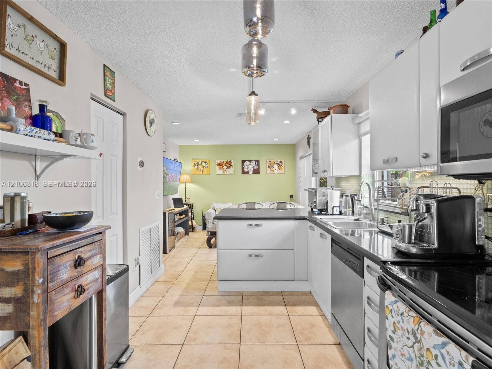9921 NW 51st Lane, Doral, FL 33178 Kitchen featuring white cabinetry, solid-surface countertops, tile flooring, recessed lighting, and a stainless steel dishwasher