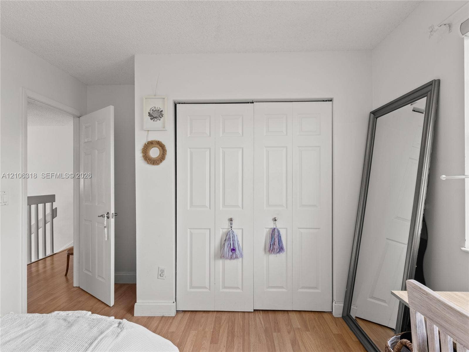 9921 NW 51st Lane, Doral, FL 33178 Wood-finish flooring, white six-panel interior doors, and double-door closet with six-panel design