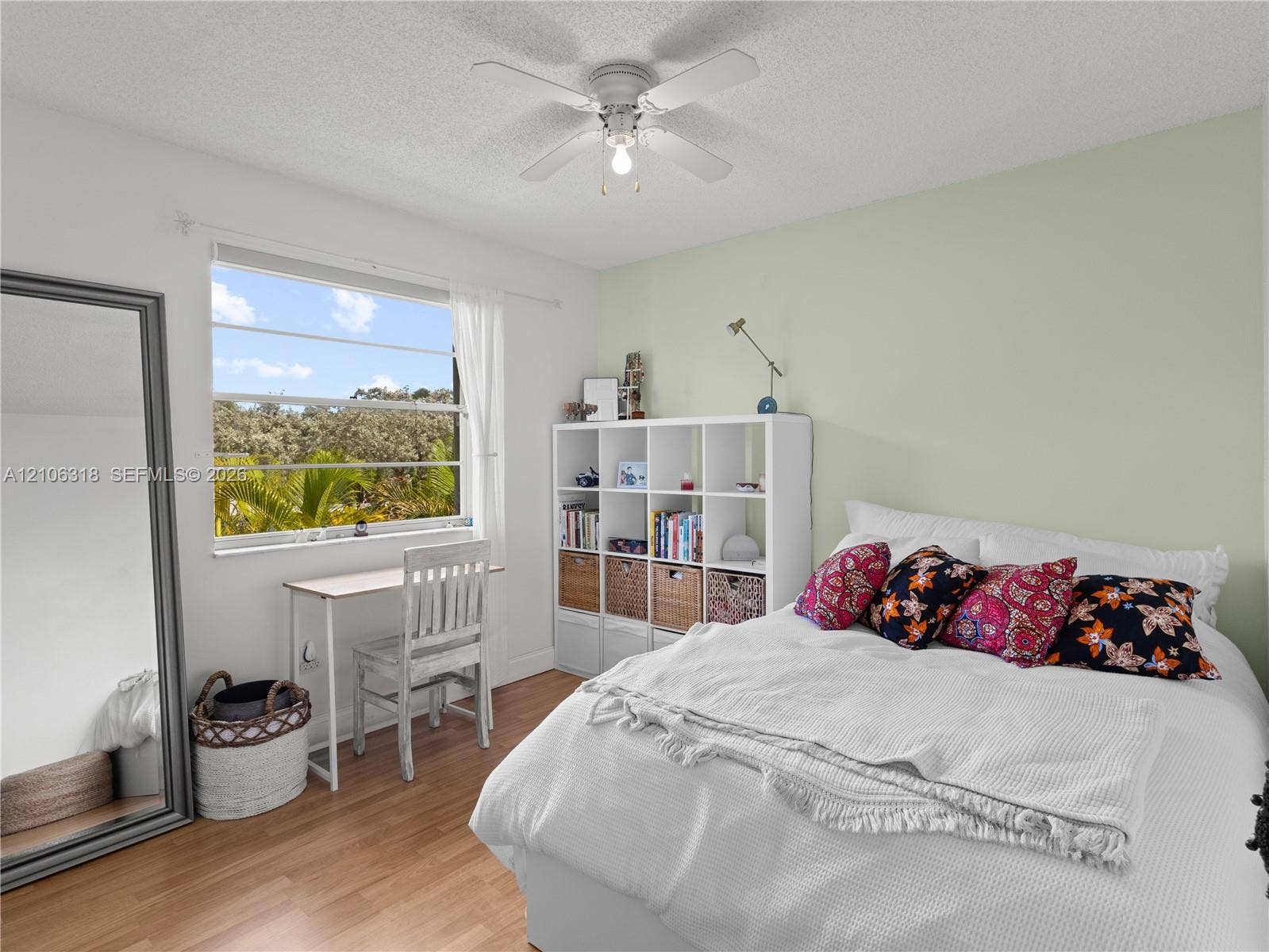 9921 NW 51st Lane, Doral, FL 33178 Bedroom featuring wood-finish flooring, a neutral accent wall, and a ceiling-mounted fan with light fixture