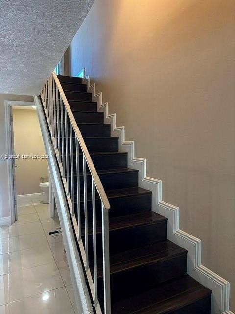 220 NW 87th Avenue, #K212, Miami, Miami, FL 33172 Staircase featuring dark wood-finish treads, white structural railing, and decorative wall molding
