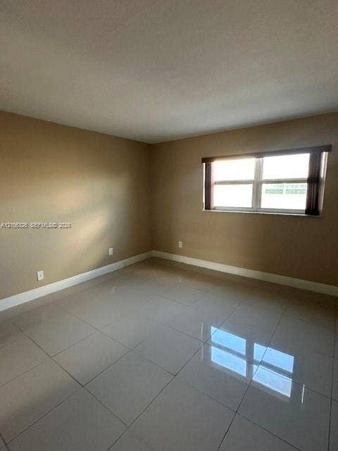 220 NW 87th Avenue, #K212, Miami, Miami, FL 33172 Room featuring large-format polished tile flooring, neutral wall paint, and a horizontal window with a fitted valance