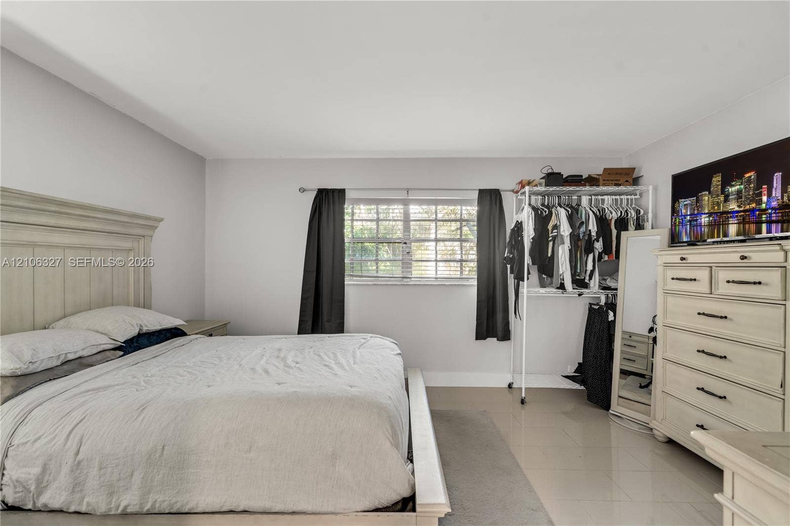 Neutral-toned interior space featuring light-colored tile flooring, smooth walls, and a multi-pane window