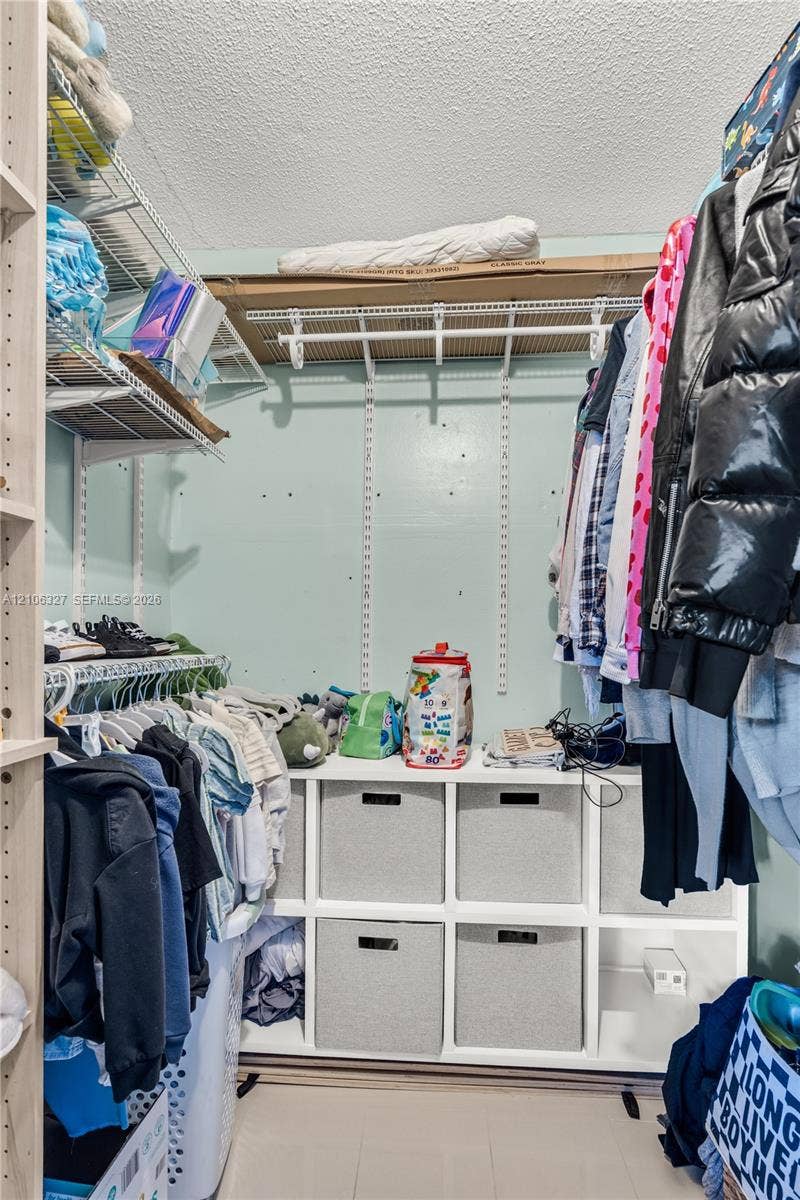 Storage area featuring adjustable white wire shelving and a built-in white laminate cubby unit