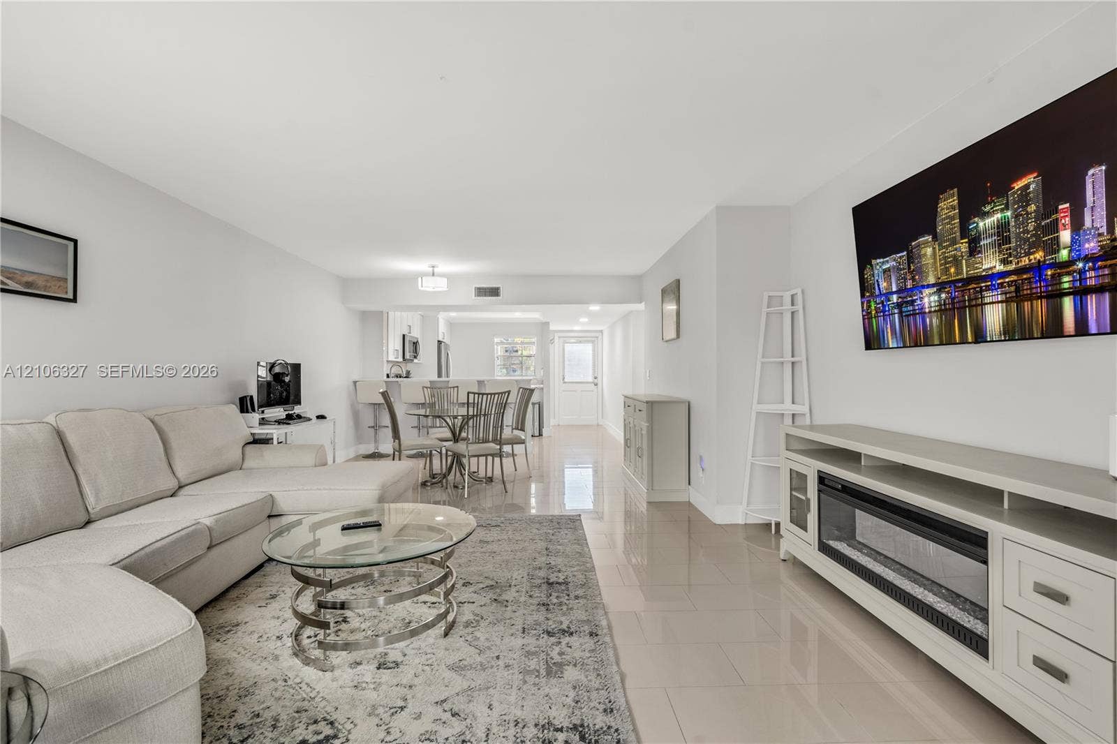 Open-concept interior featuring large-format tile flooring, recessed lighting, and a built-in electric fireplace unit