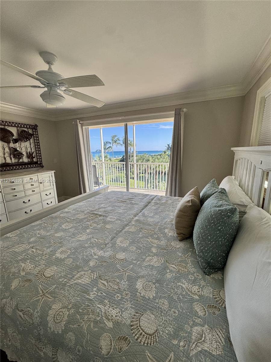 3600 N Ocean Drive, #423, Riviera Beach, Riviera Beach, FL 33404 Sliding glass doors opening to a railed balcony, crown molding, and a ceiling fan