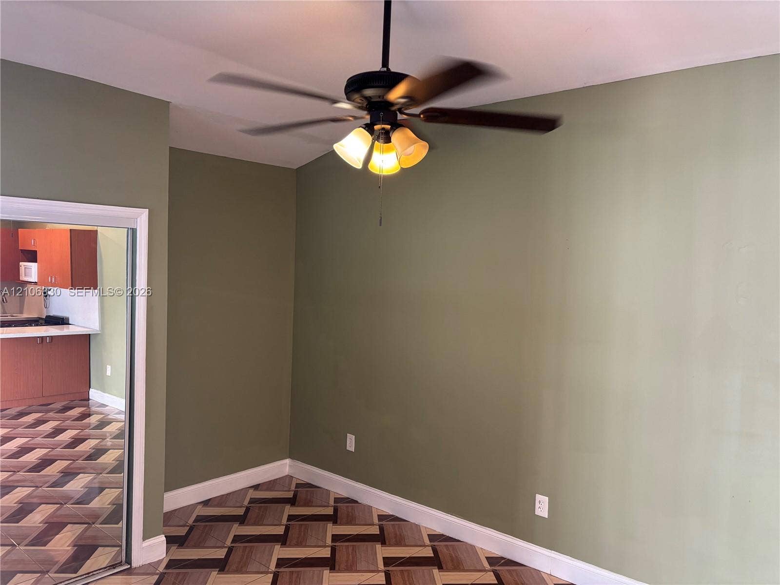 Geometric-patterned tile flooring, vaulted ceiling, and integrated three-light ceiling fan