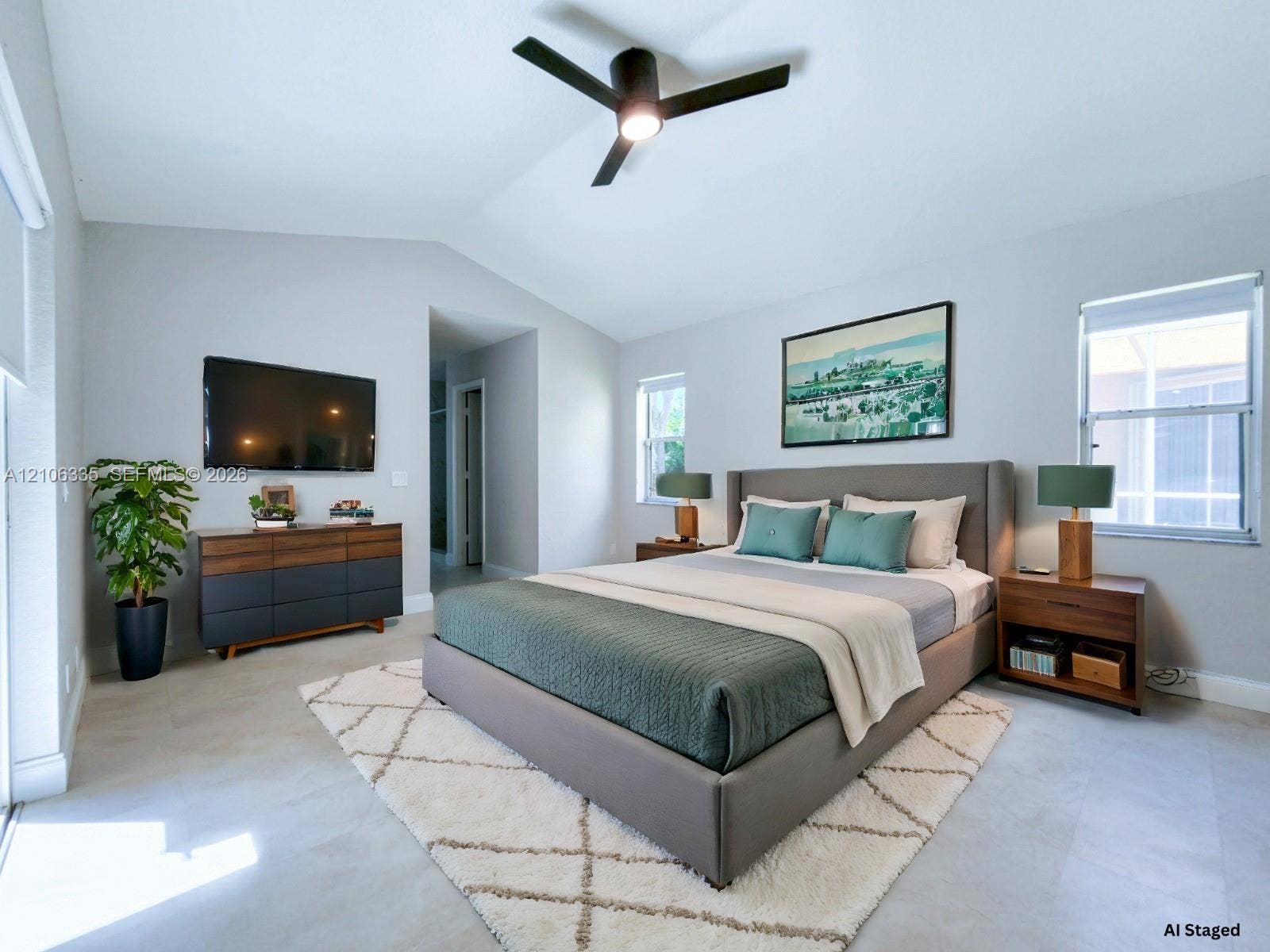 Vaulted ceilings, neutral walls, light-toned tile flooring, and a modern matte black ceiling fan