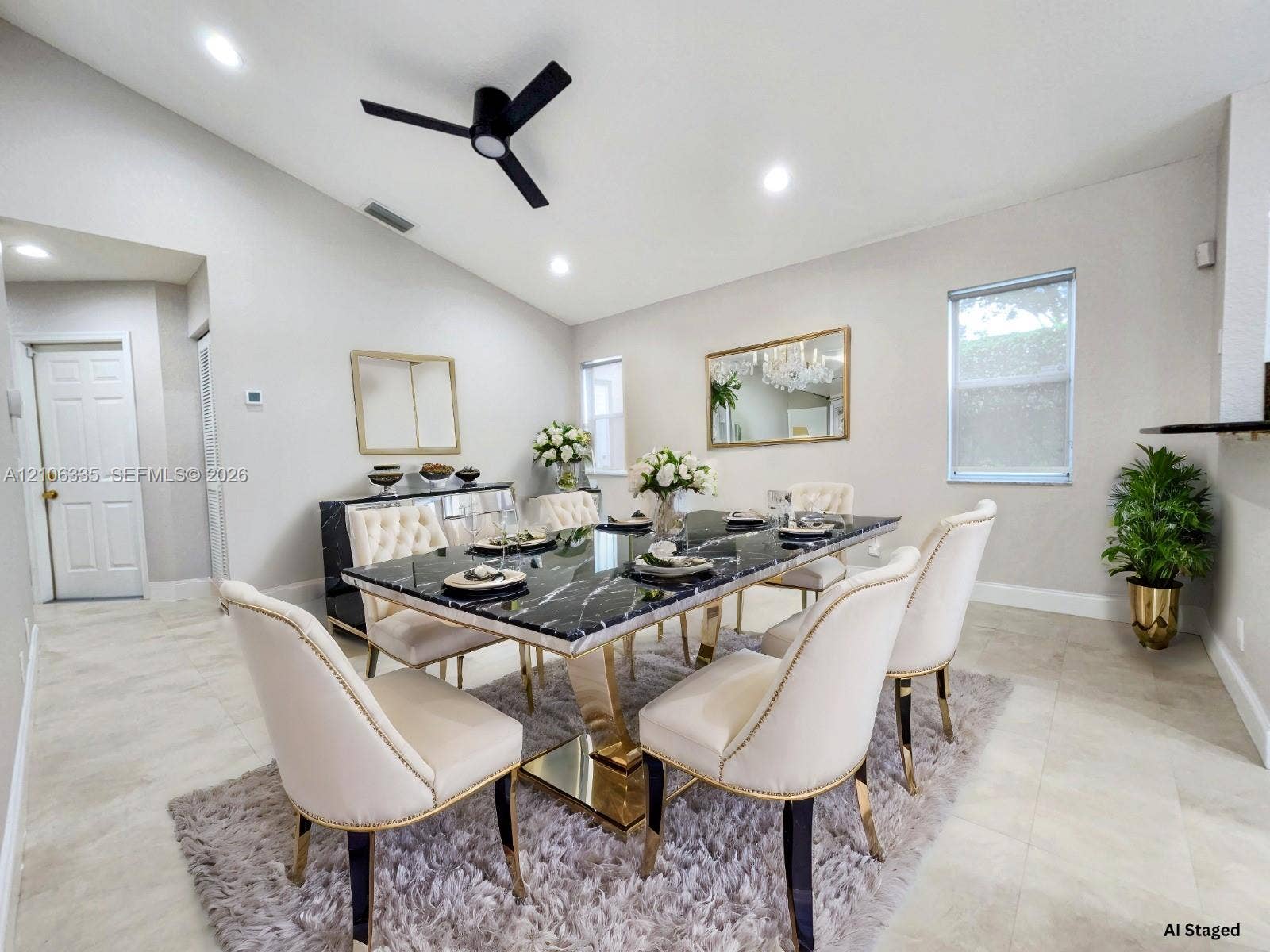 Vaulted ceilings, neutral wall tones, large-format tile flooring, matte black ceiling fan, and recessed lighting