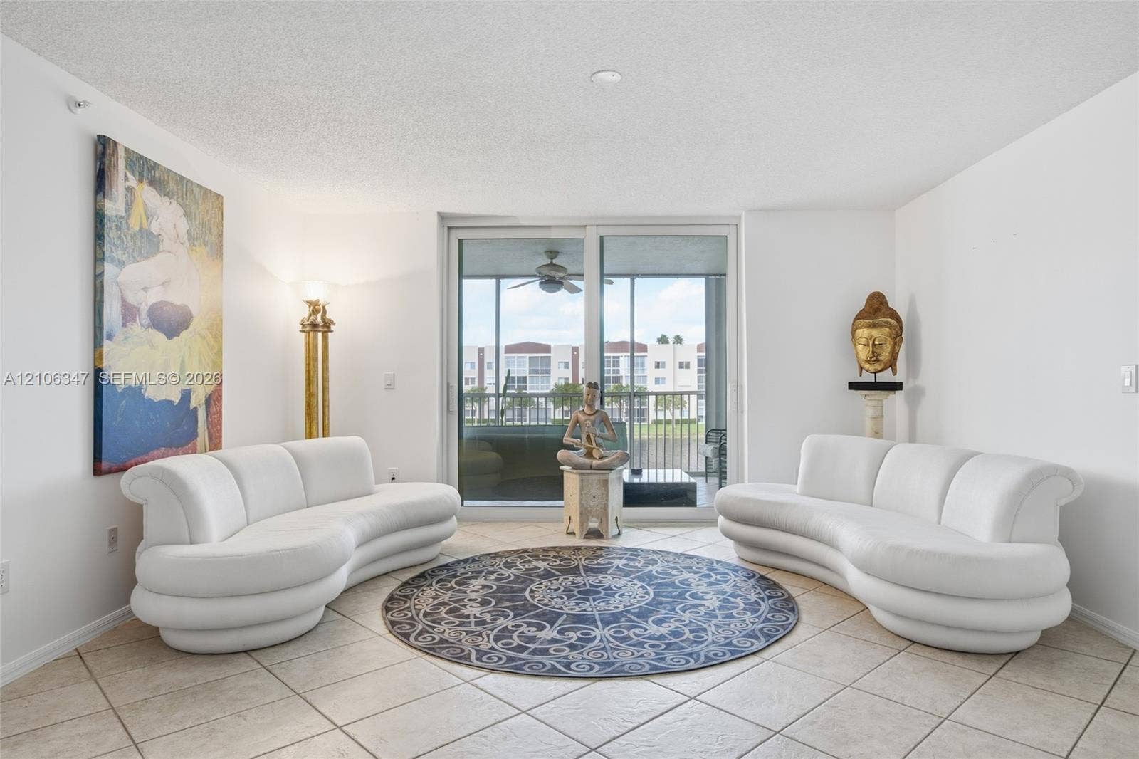 7759 Granville Drive, #306, Tamarac, FL 33321 Living area featuring large-format ceramic tile flooring and full-height sliding glass doors with direct access to a screened-in balcony