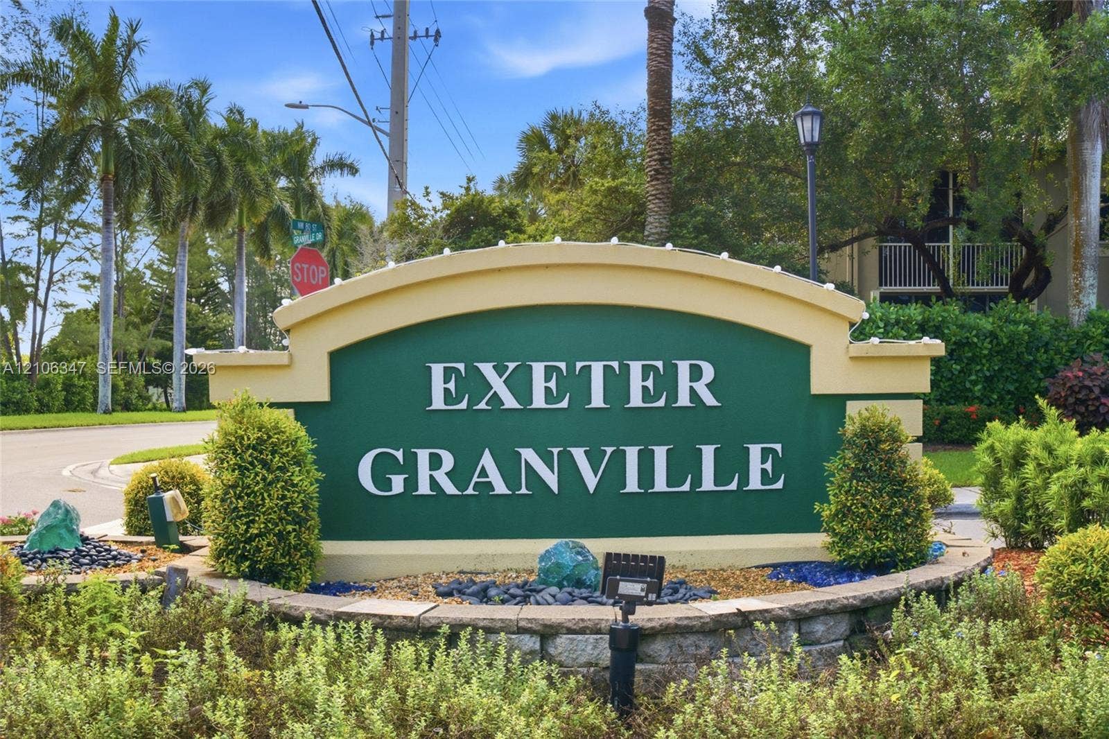 7759 Granville Drive, #306, Tamarac, FL 33321 Architectural community monument sign featuring a raised-relief facade, stone-base edging, integrated low-voltage lighting, and professional landscape design