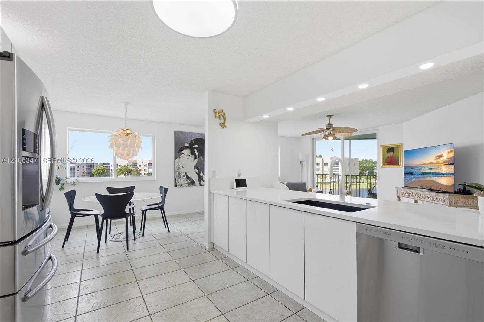7759 Granville Drive, #306, Tamarac, FL 33321 Kitchen featuring white flat-panel cabinetry, solid-surface countertops, recessed lighting, tile flooring, and stainless steel appliances
