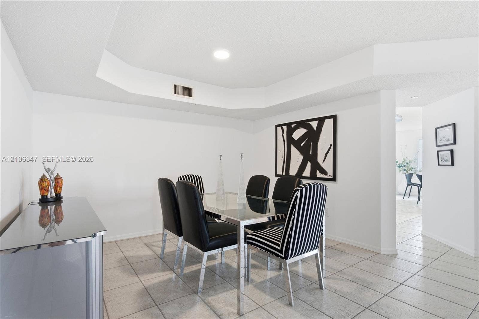 7759 Granville Drive, #306, Tamarac, FL 33321 Neutral interior featuring a tiered tray ceiling and large-format ceramic tile flooring