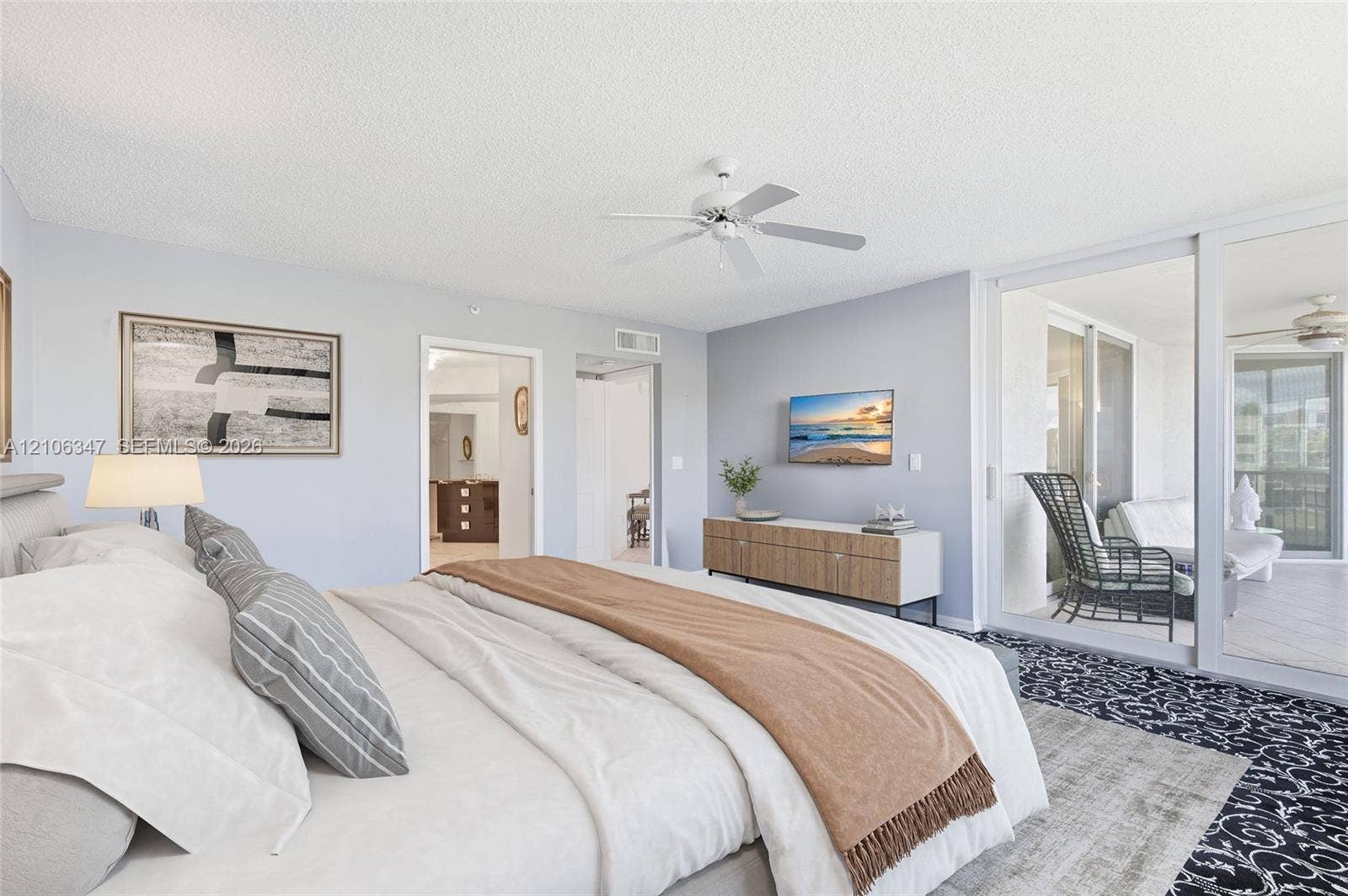 7759 Granville Drive, #306, Tamarac, FL 33321 Spacious room featuring a ceiling fan, wall-to-wall carpeting, and expansive sliding glass doors providing outdoor access