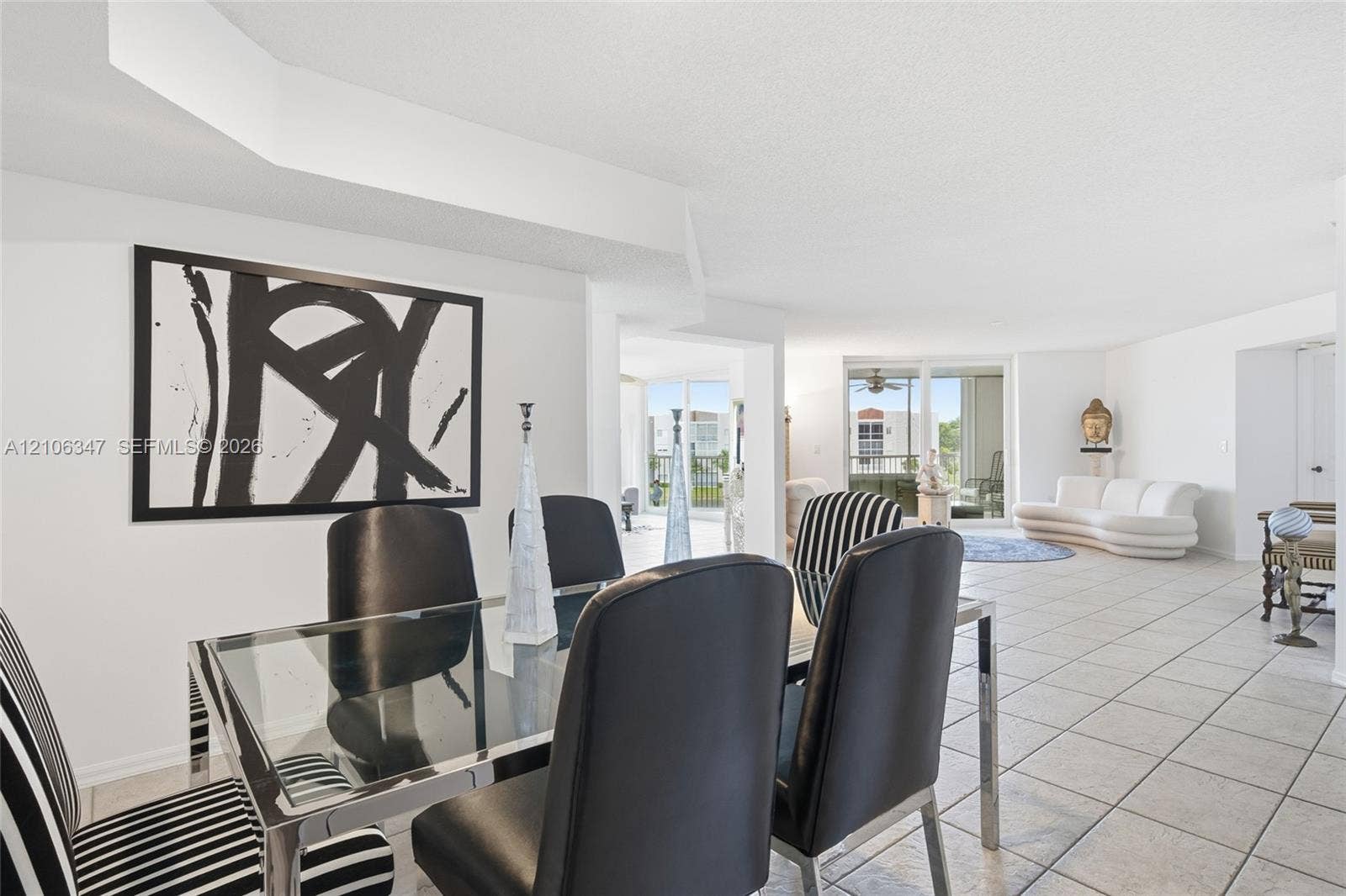 7759 Granville Drive, #306, Tamarac, FL 33321 Open-concept interior featuring large-format ceramic tile flooring, recessed ceiling design, and floor-to-ceiling glass sliding doors