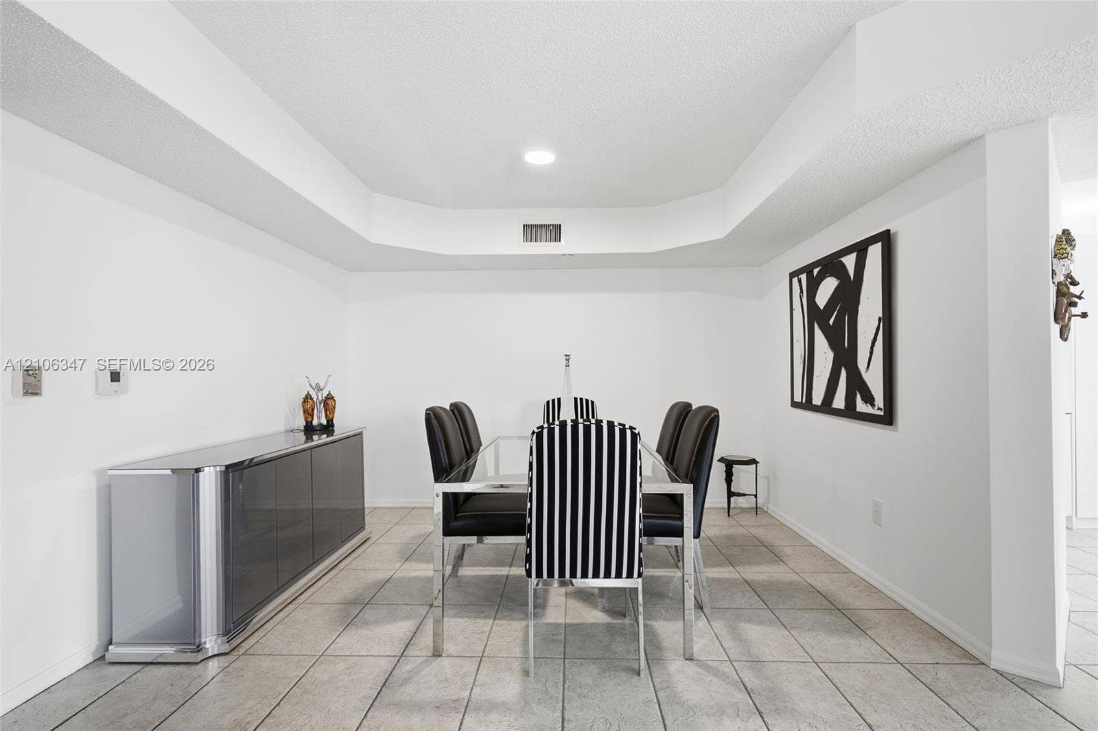 7759 Granville Drive, #306, Tamarac, FL 33321 Dining area featuring tile flooring, recessed ceiling lighting, and a tiered tray ceiling design