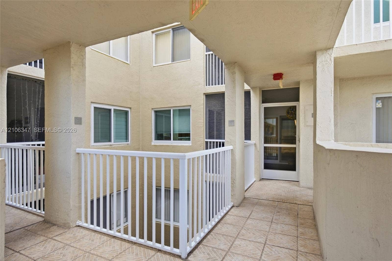 7759 Granville Drive, #306, Tamarac, FL 33321 Stucco exterior featuring tile flooring, metal railings, and multi-pane windows