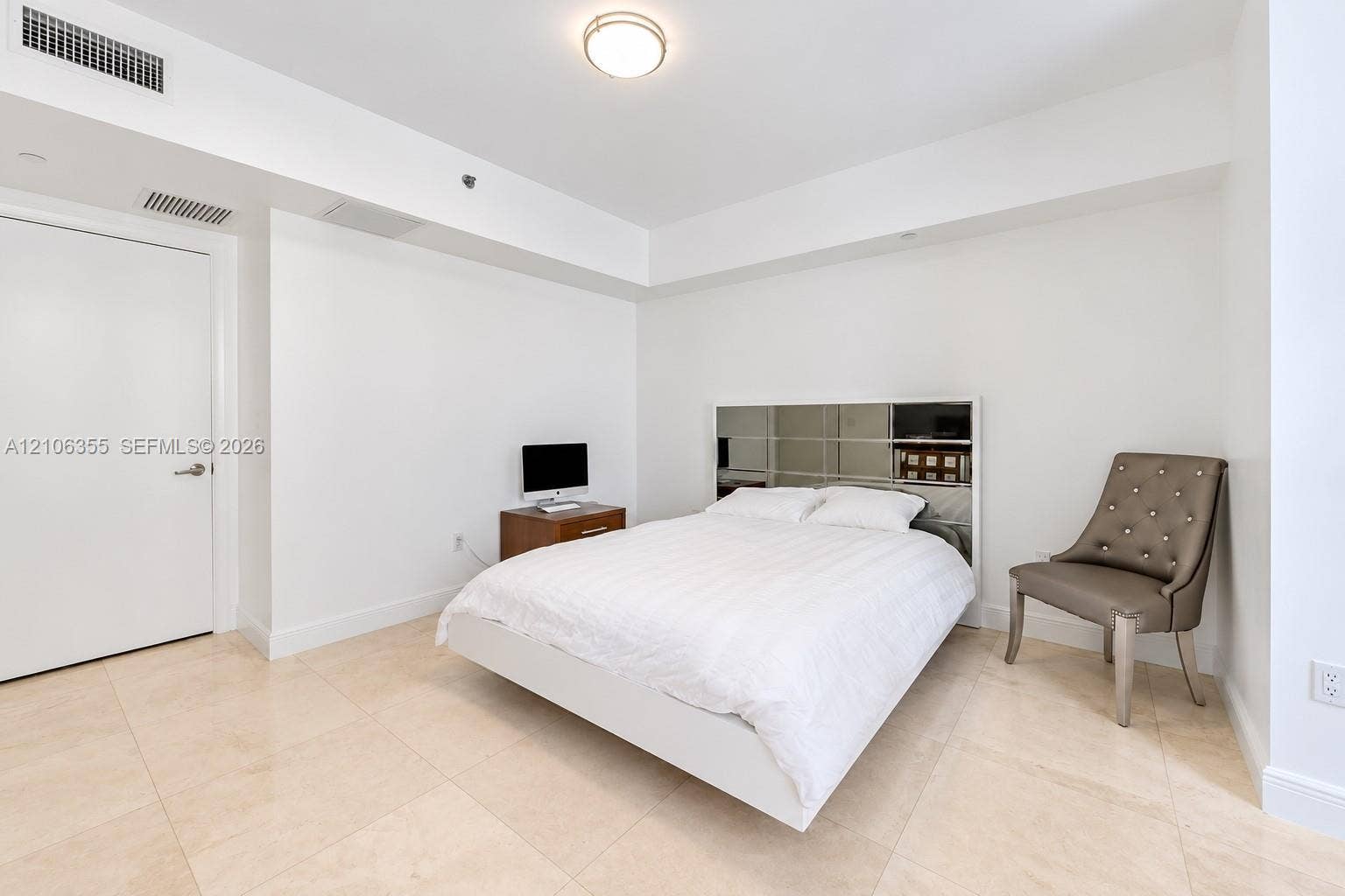 495 Brickell Avenue, #1906, Miami, Miami, FL 33131 Spacious room featuring neutral stone tile flooring, high ceilings with recessed lighting, and a crisp white aesthetic