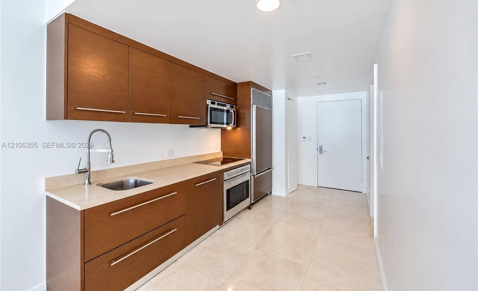 495 Brickell Avenue, #1906, Miami, Miami, FL 33131 Kitchen featuring wood-finish cabinetry, solid surface countertops, stainless steel integrated refrigerator, built-in electric cooktop, and tile flooring