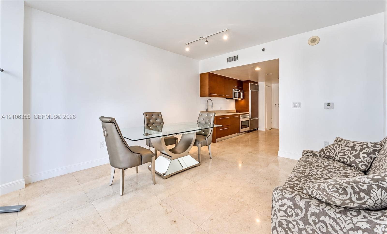 495 Brickell Avenue, #1906, Miami, Miami, FL 33131 Stone flooring, track lighting, and kitchen featuring wood-finish cabinetry, built-in stainless steel appliances, and stone countertops