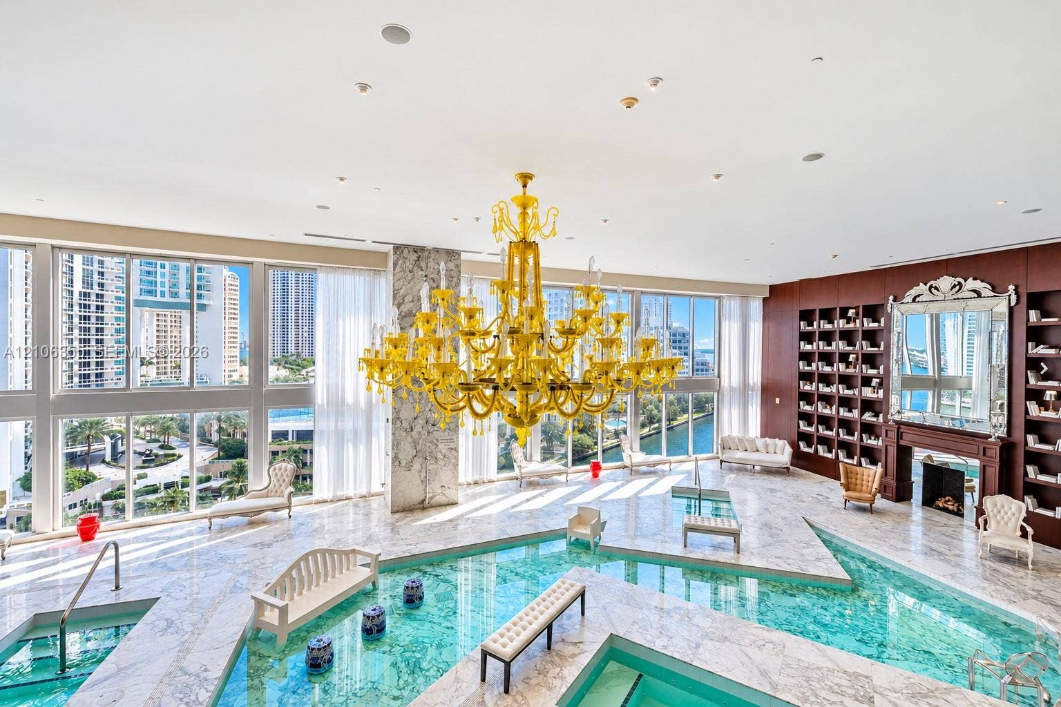 495 Brickell Avenue, #1906, Miami, Miami, FL 33131 Indoor pool area featuring natural stone flooring, floor-to-ceiling windows, an expansive yellow chandelier, built-in shelving, and a decorative fireplace