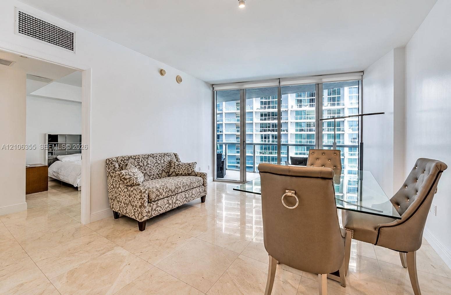 495 Brickell Avenue, #1906, Miami, Miami, FL 33131 Open-concept interior featuring large-format stone flooring, floor-to-ceiling windows, and a glass balcony door