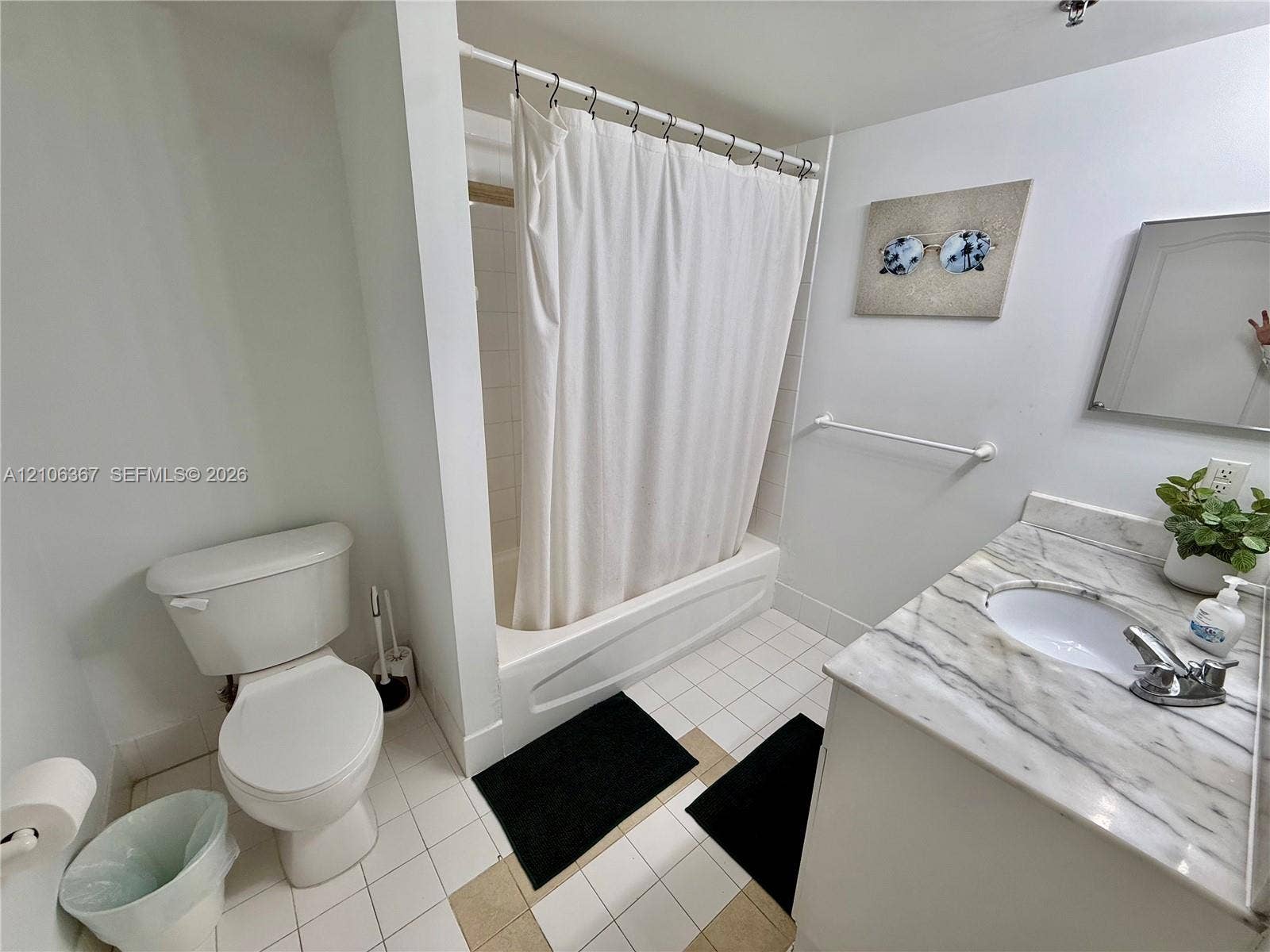 Bathroom featuring a vanity with a white-veined countertop, integrated sink, tub-shower combination, and tiled flooring