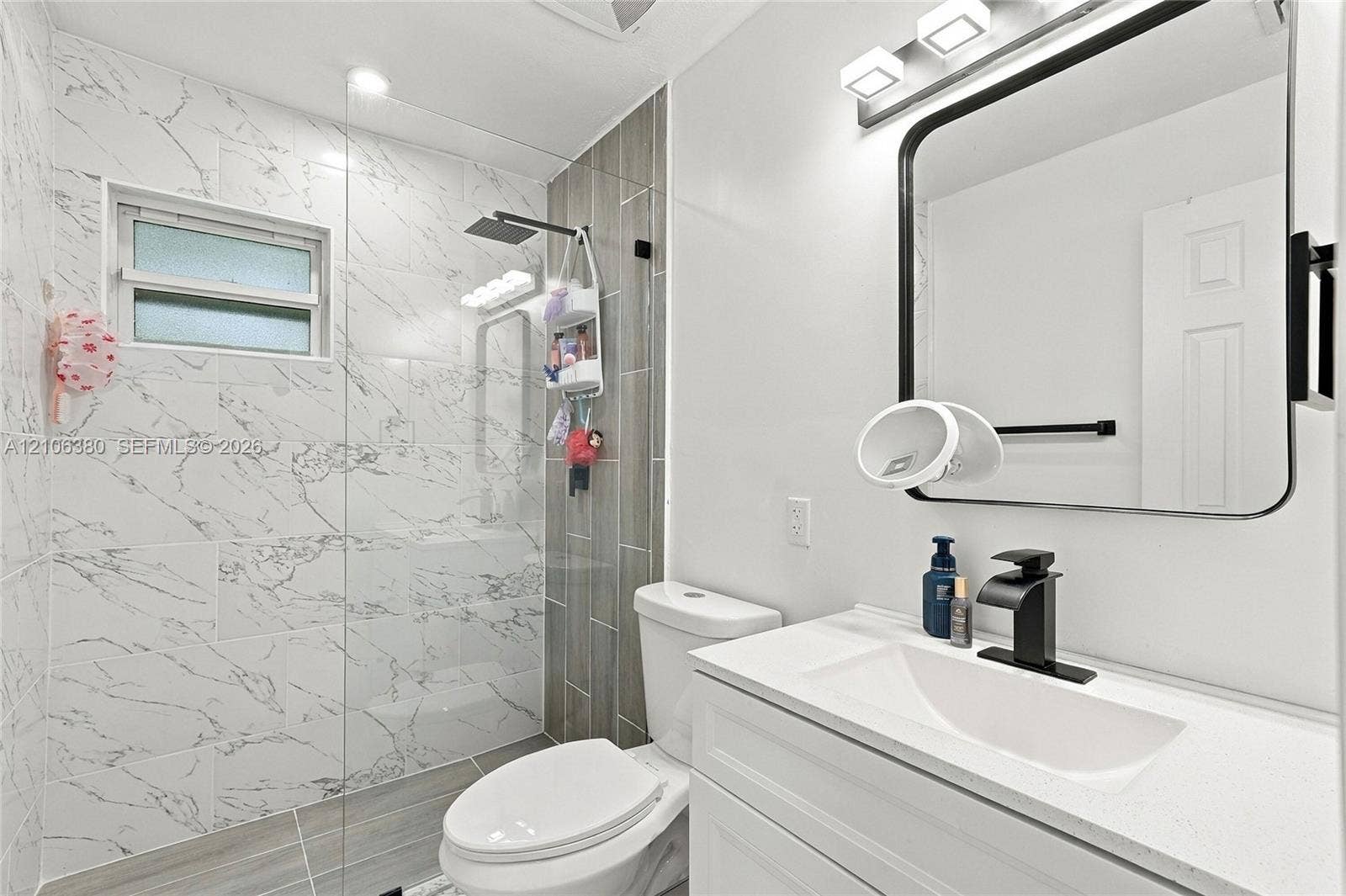 Bathroom featuring a vanity with a white composite countertop, integrated rectangular sink, and matte black faucet