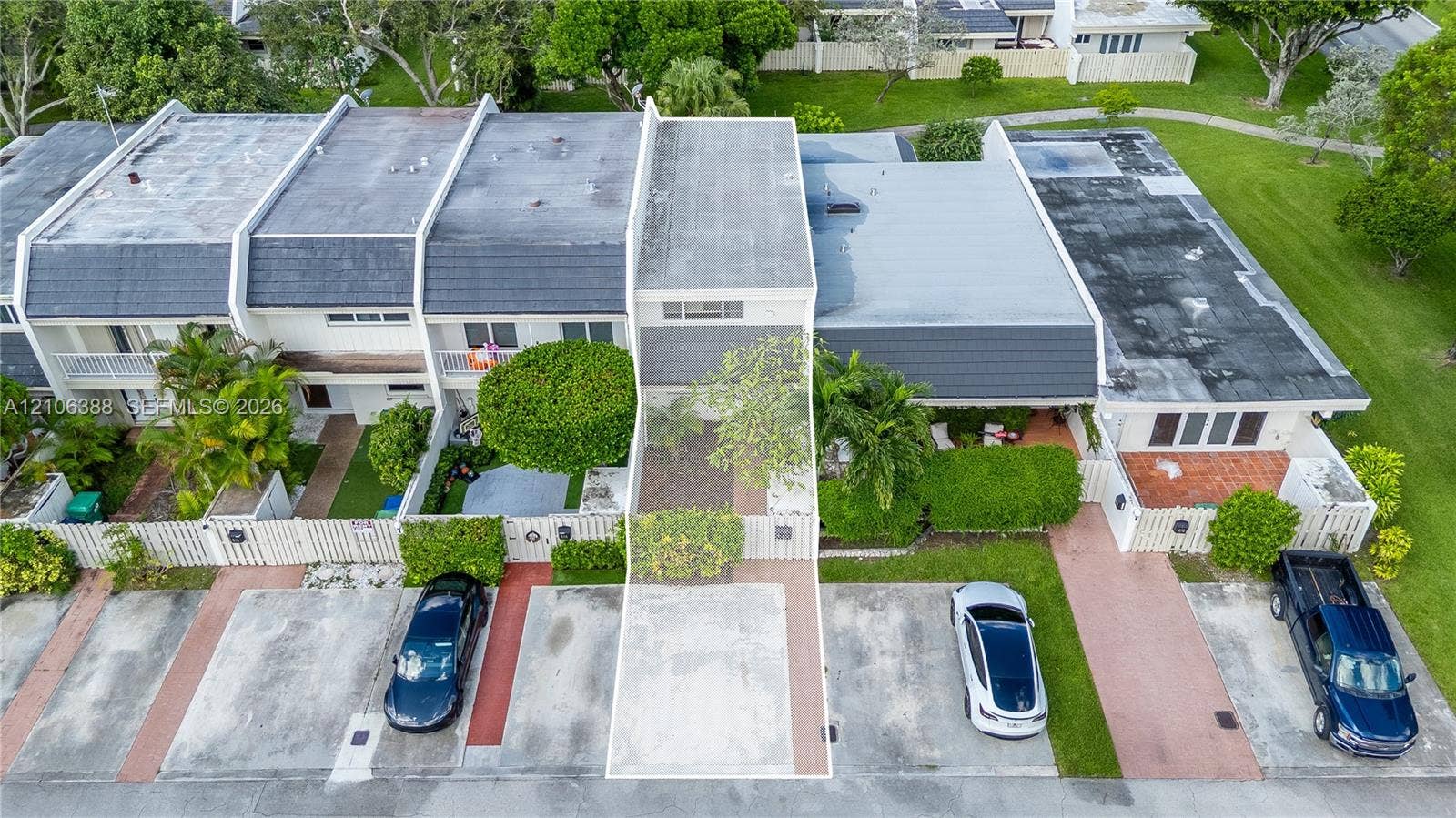 8110 SW 82nd Court, Miami, FL 33143 Two-story exterior featuring a private gated courtyard, dedicated concrete parking space, and mature perimeter landscaping