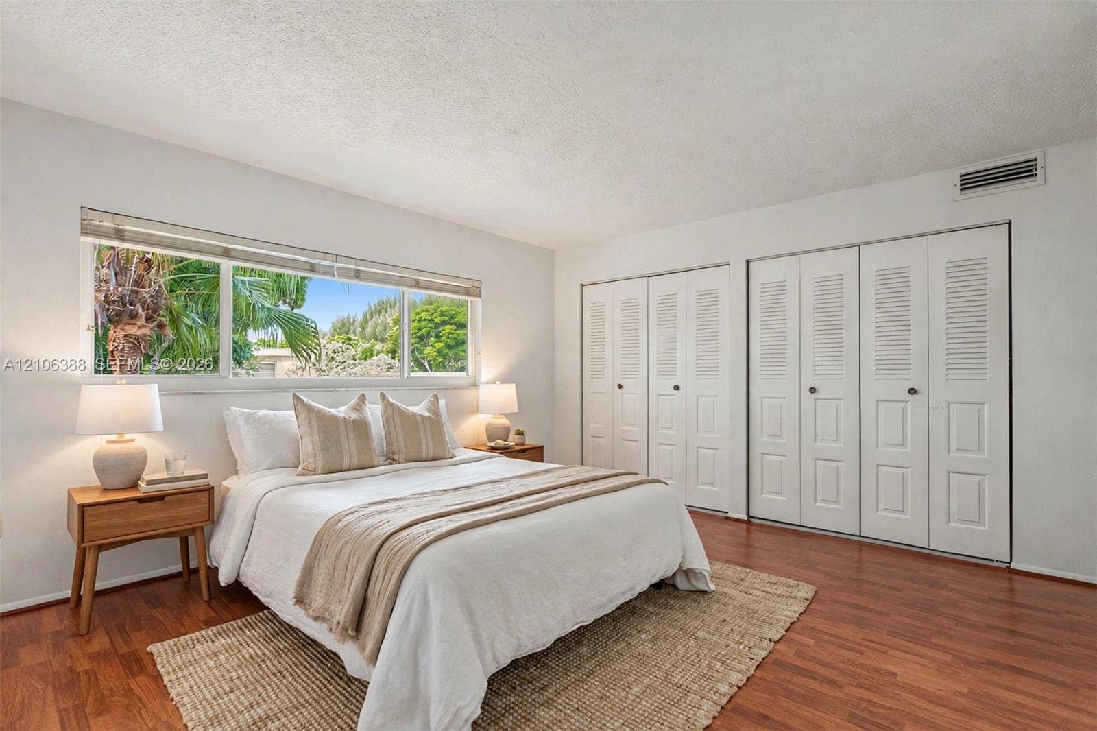 8110 SW 82nd Court, Miami, FL 33143 Horizontal sliding window with exterior greenery, wood-finish flooring, and double-door louvered closets