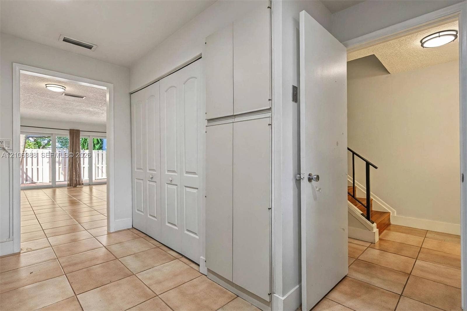 8110 SW 82nd Court, Miami, FL 33143 Ceramic tile flooring throughout, built-in floor-to-ceiling storage cabinetry, flush-mount lighting fixtures, and a staircase featuring a wooden handrail