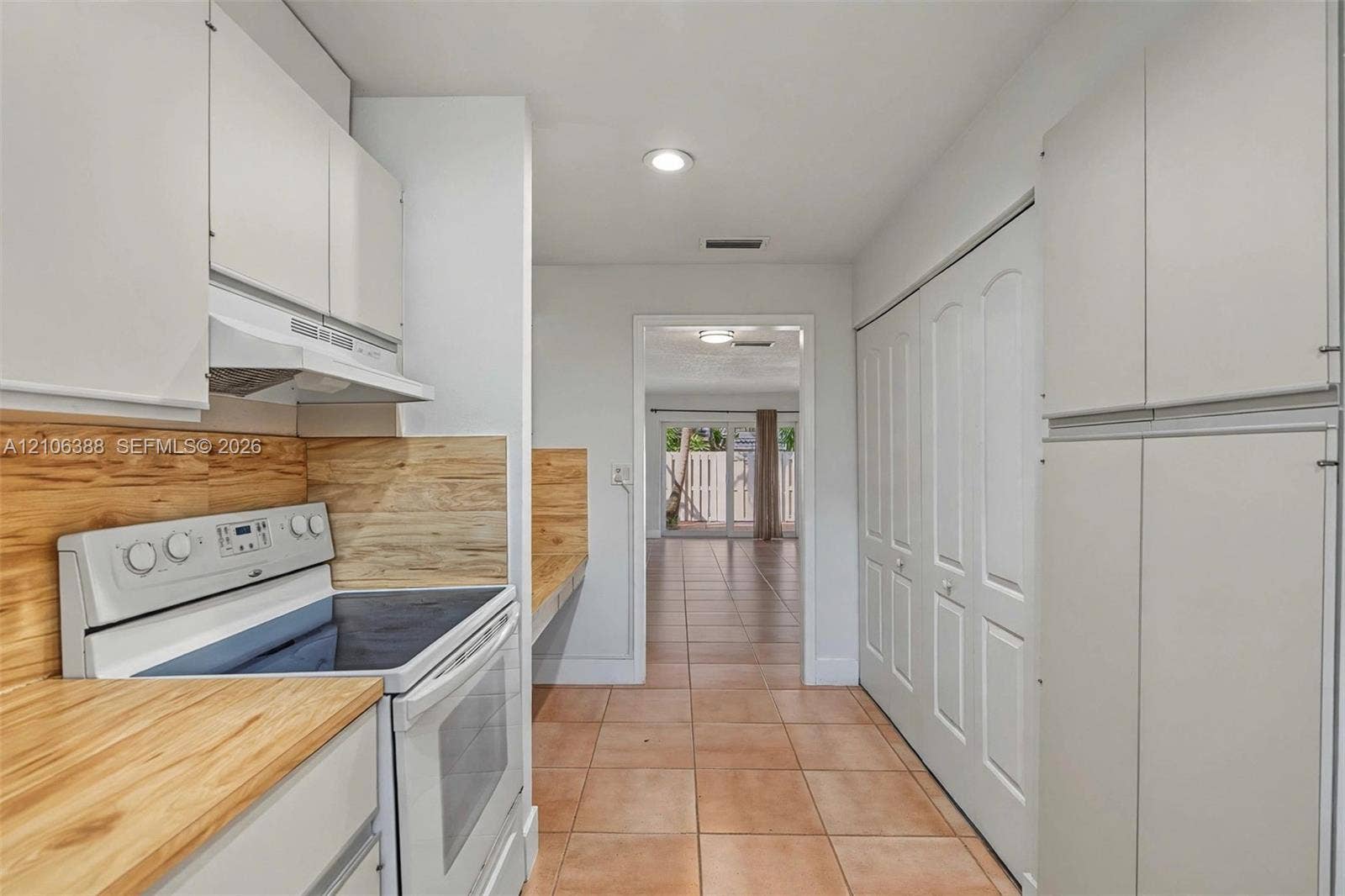 8110 SW 82nd Court, Miami, FL 33143 Kitchen featuring white cabinetry, wood-finish countertops, wood-finish backsplash, built-in electric range, and ceramic tile flooring