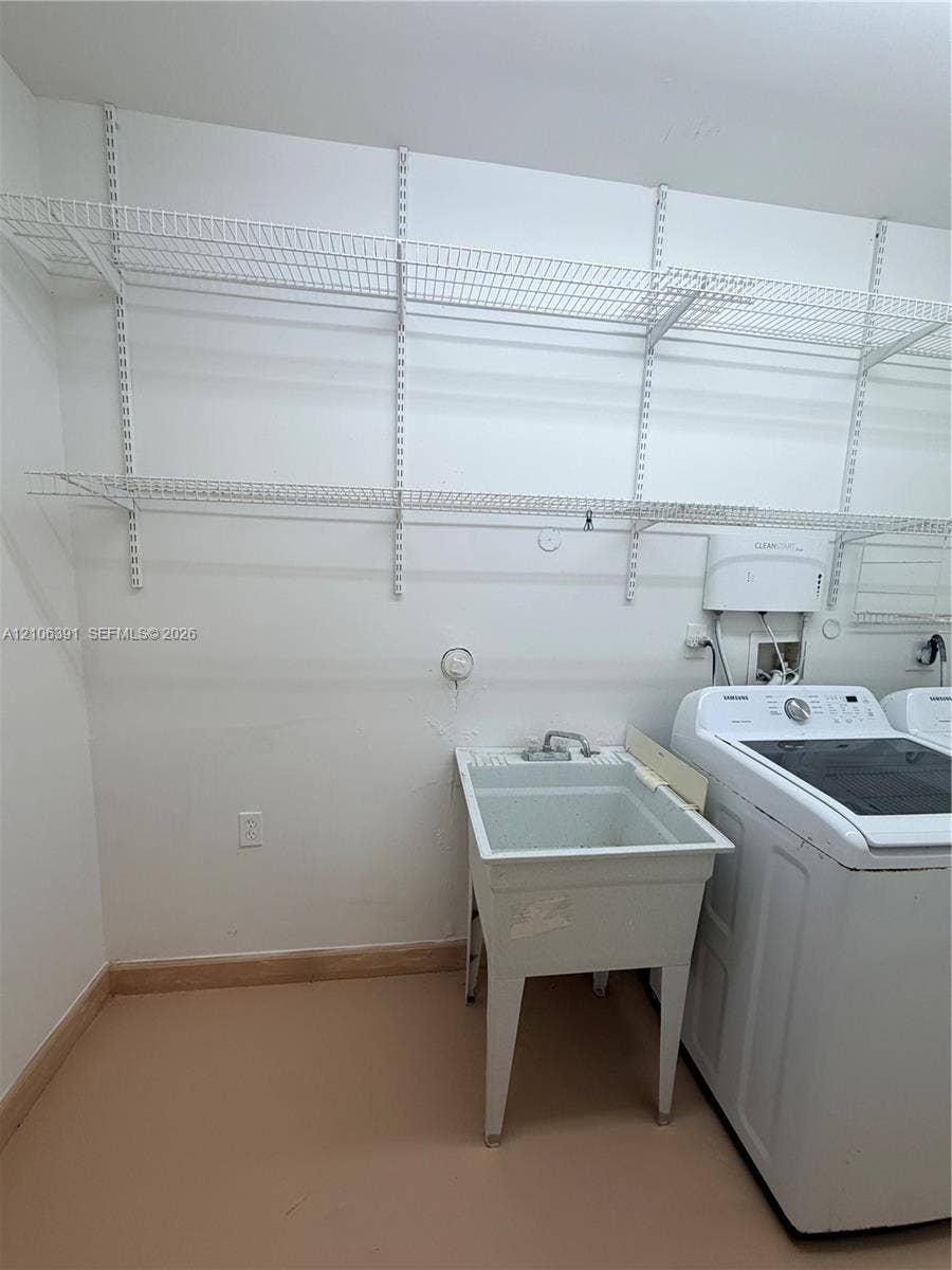 Utility space featuring white wire wall-mounted shelving and a basin sink with a dual-handle faucet
