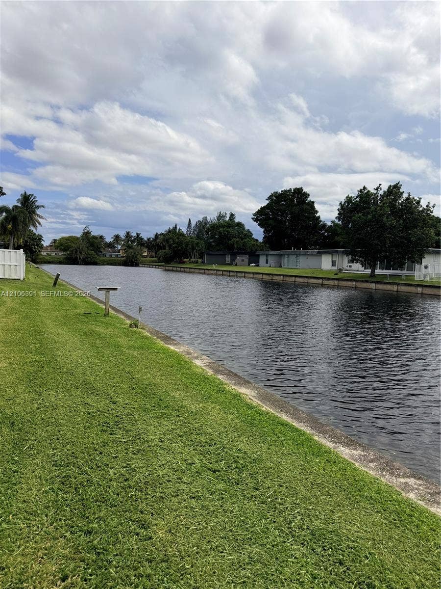 Waterfront lot featuring a concrete bulkhead and expansive grass lawn