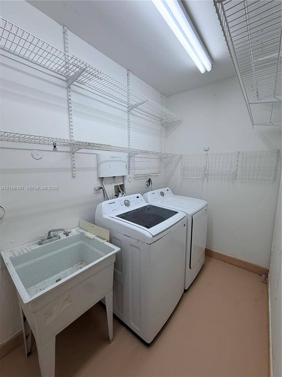 Utility area featuring a freestanding basin, metal wall-mounted shelving, and overhead fluorescent lighting